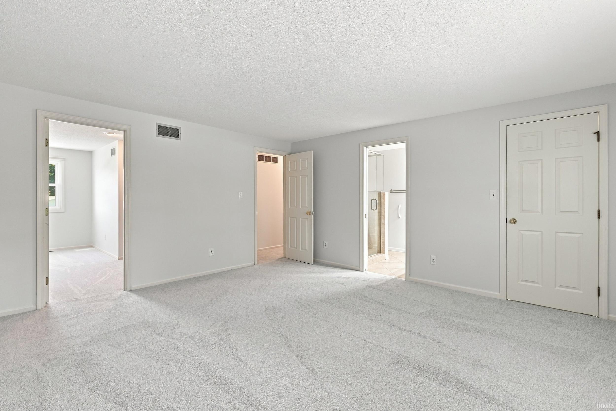 Expansive room featuring light gray carpeting and freshly painted walls