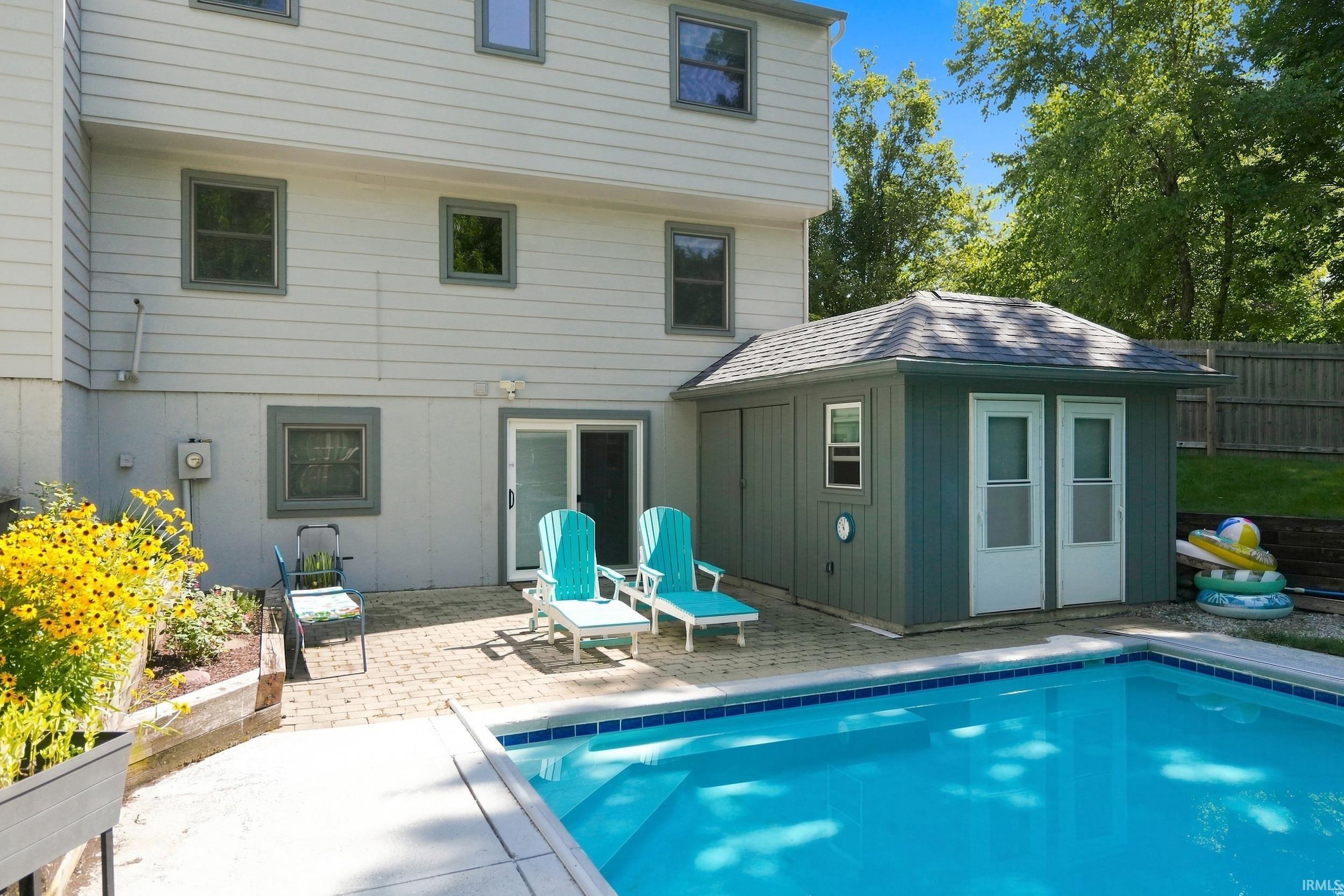 In-ground swimming pool with a surrounding concrete and paver patio