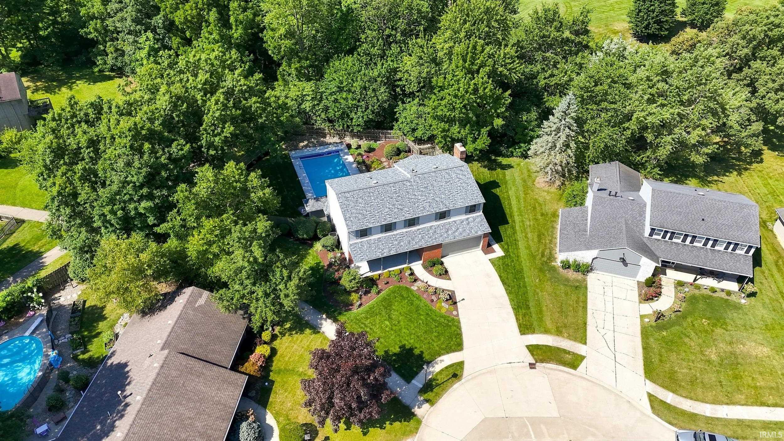 Contemporary two-story residence featuring a gray shingle roof, attached garage, and a concrete driveway
