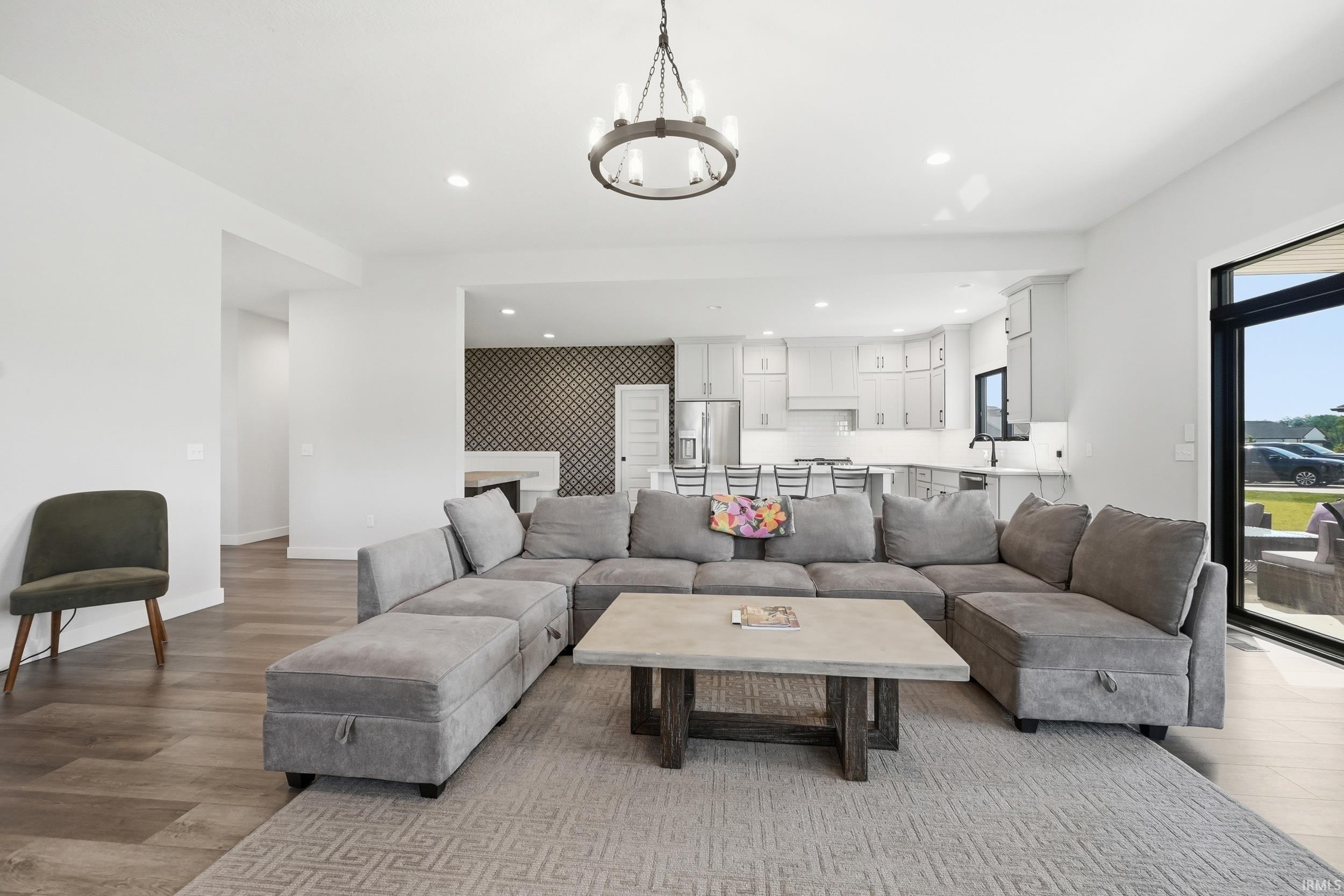 Open concept living area featuring wood-finish flooring, recessed lighting, and a contemporary chandelier
