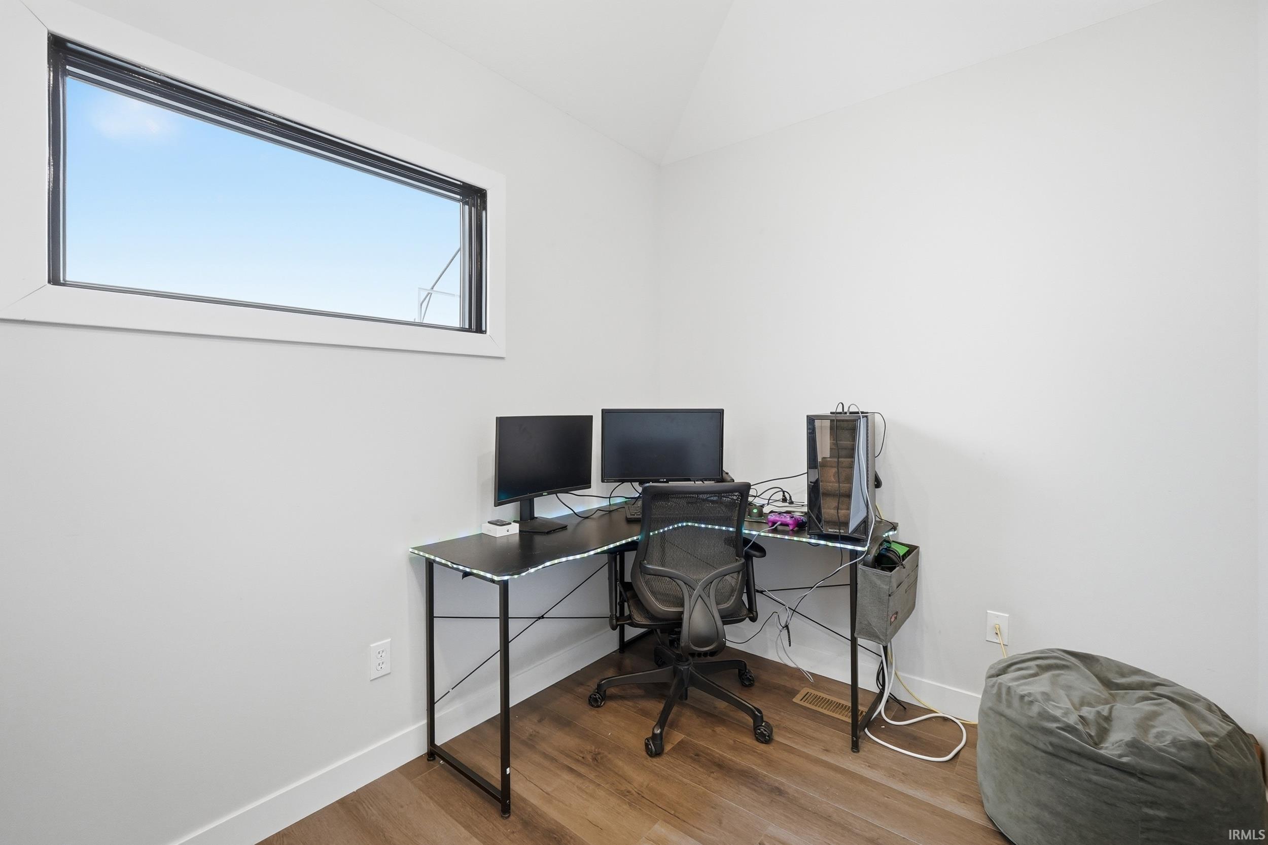 Room with light gray walls, wood-finish flooring, and white trim