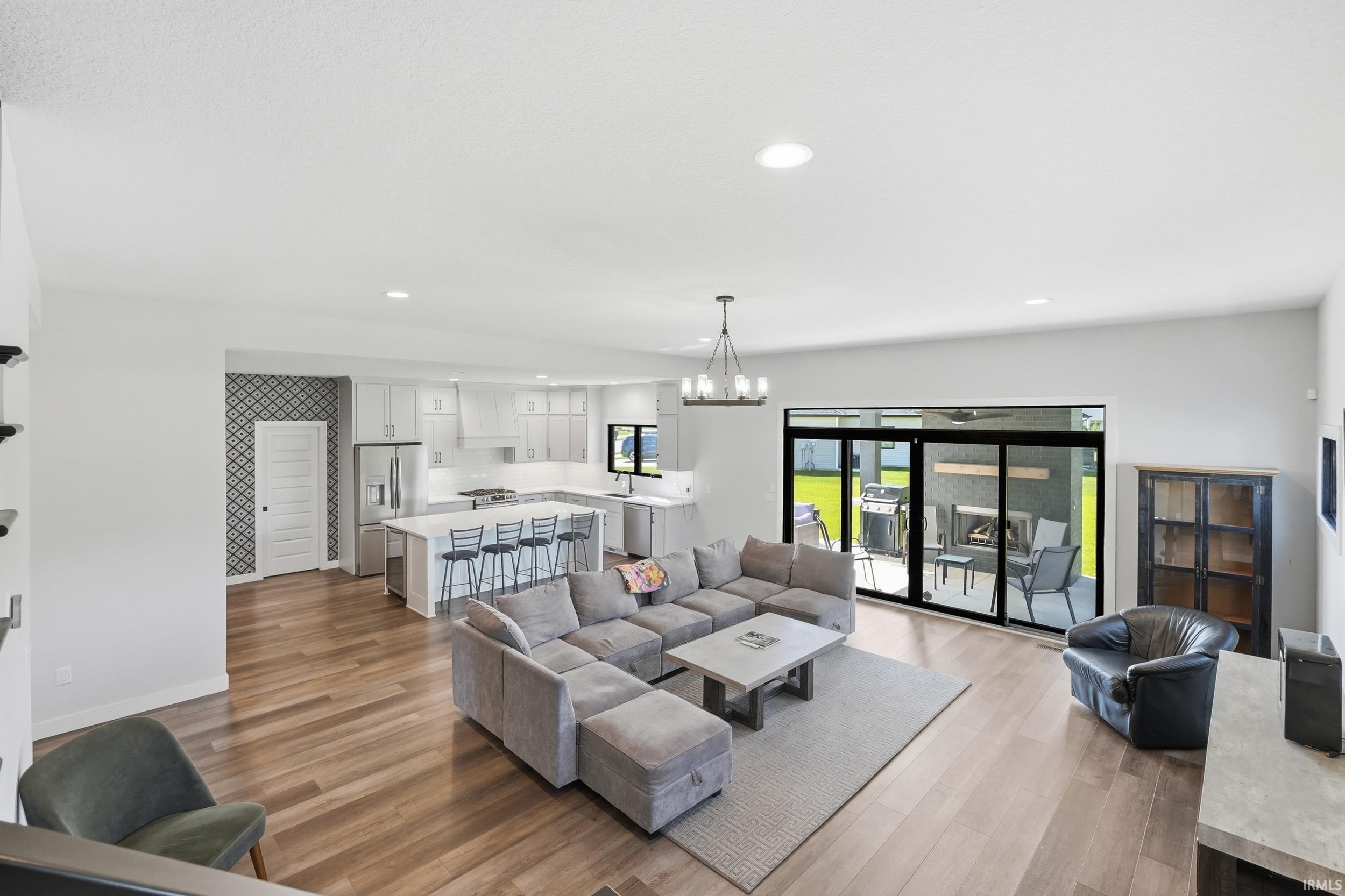 Spacious open-concept living area featuring wood-finish flooring and recessed lighting