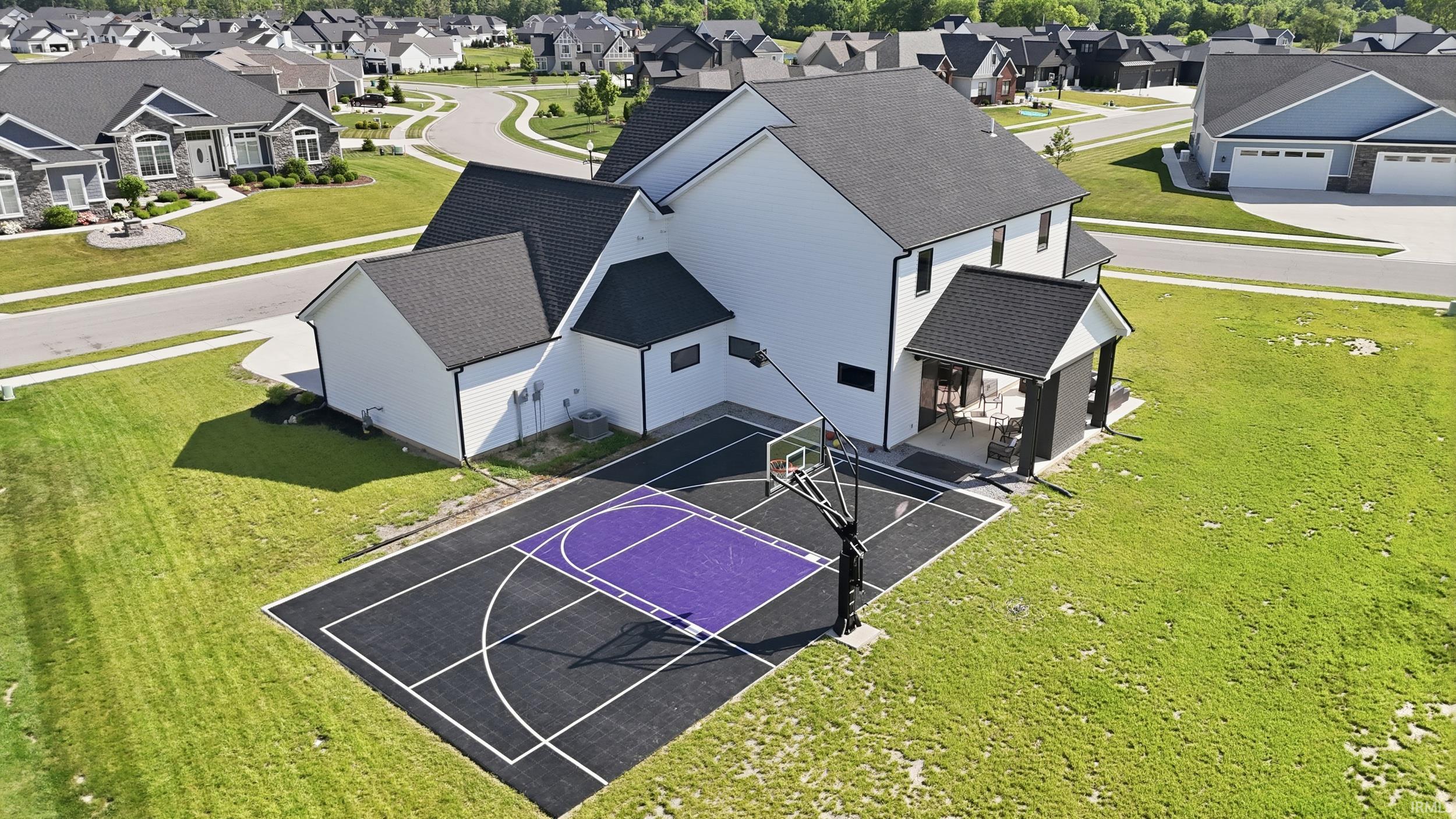 Expansive backyard court featuring a purple and black surface with white court lines