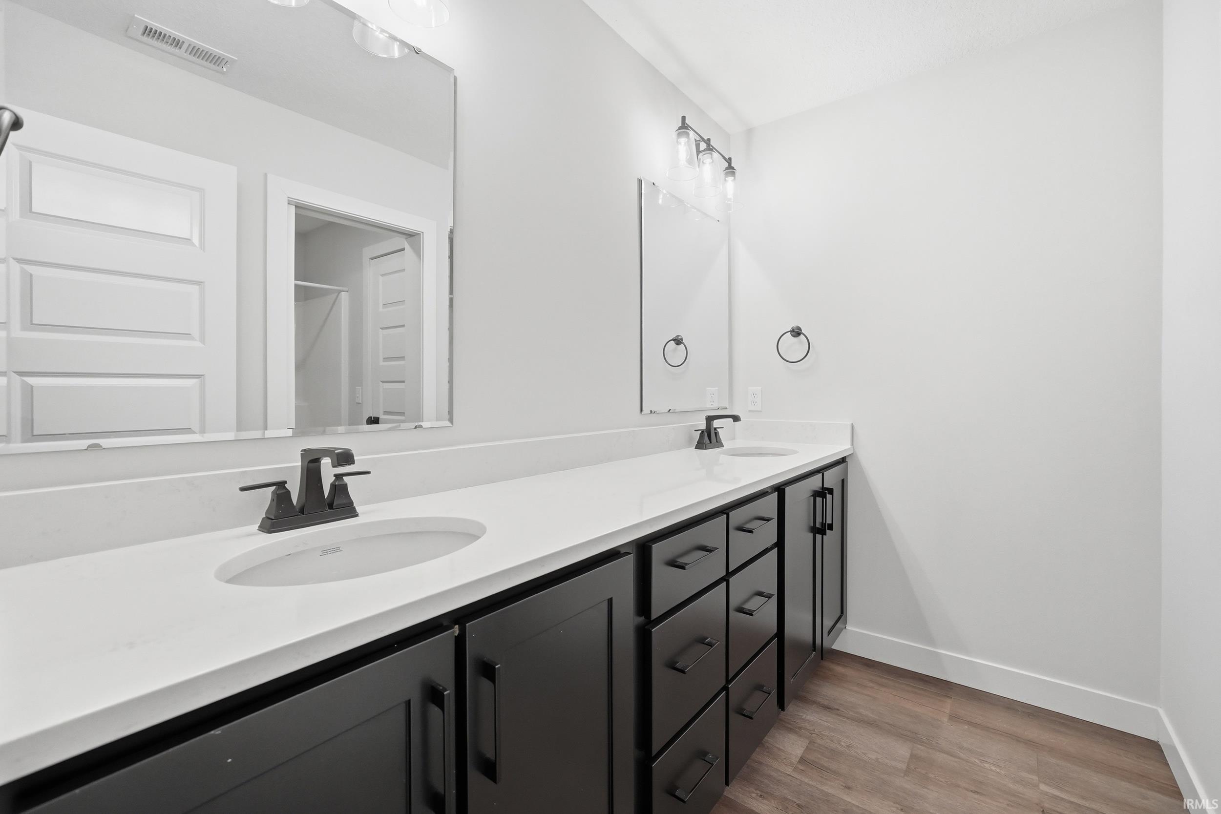 Bathroom featuring a dual vanity with white countertops and matte black cabinetry
