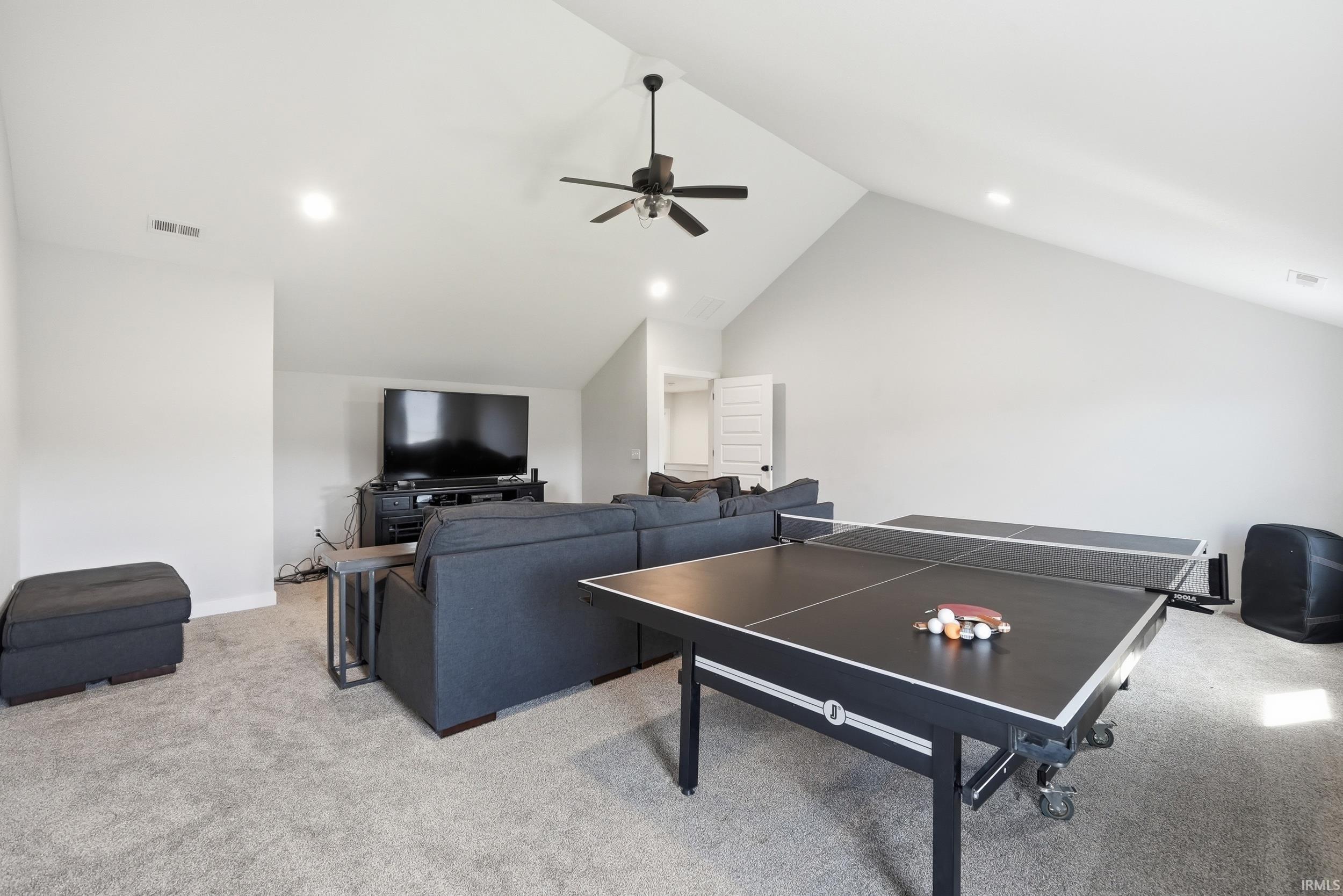 Spacious bonus room featuring vaulted ceilings, recessed lighting, and soft gray carpeting