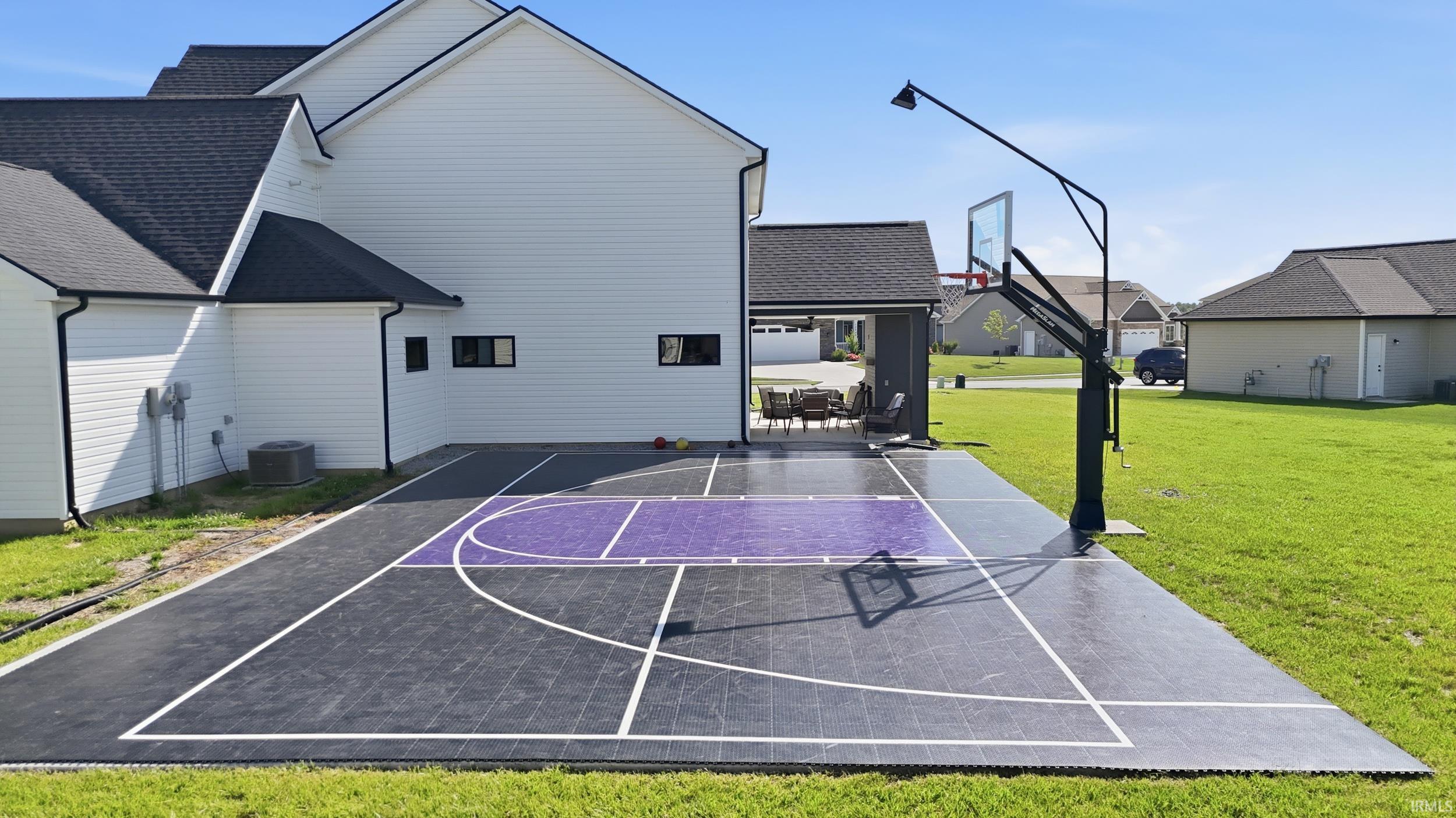 Outdoor sport court featuring a basketball hoop with an integrated light
