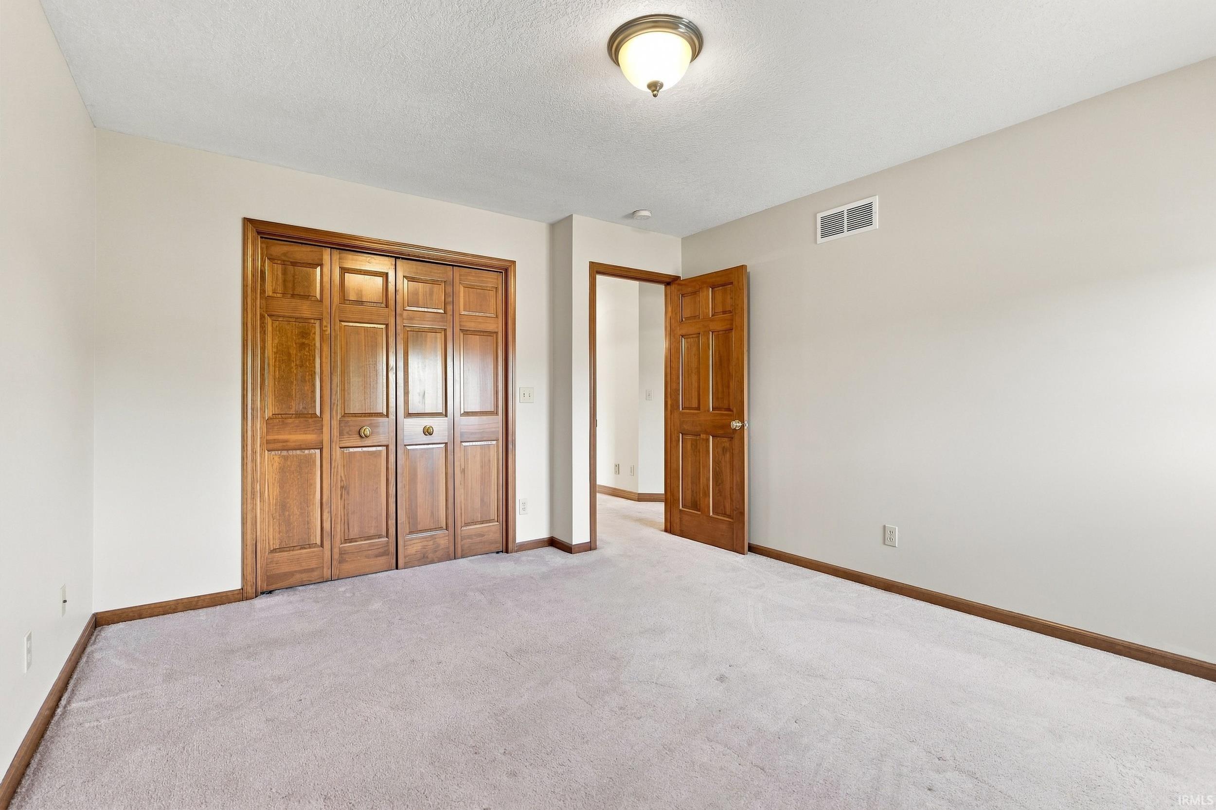 Neutral-toned room with light gray carpeting and white walls