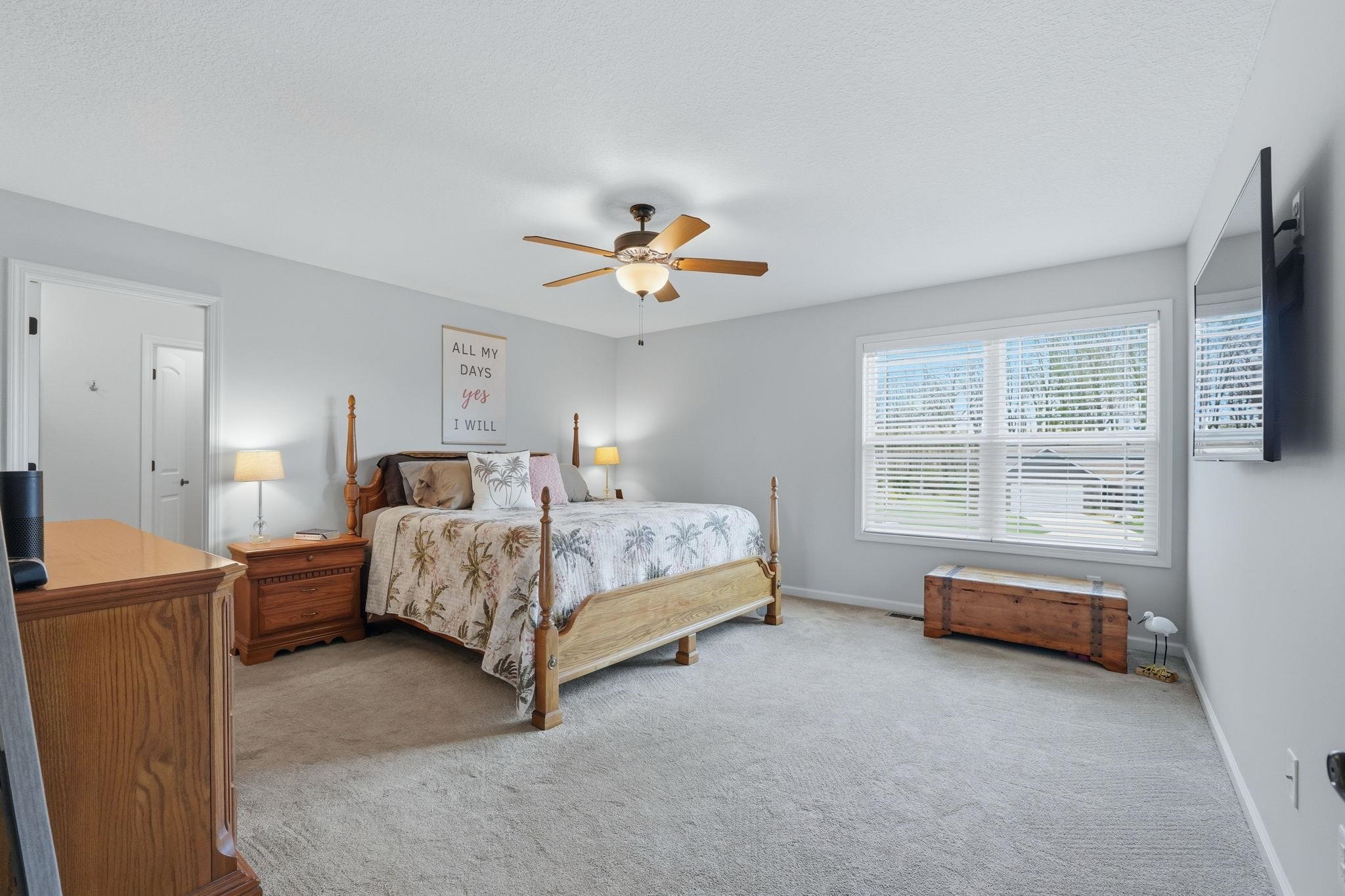 Carpeted bedroom featuring ceiling fan and baseboards