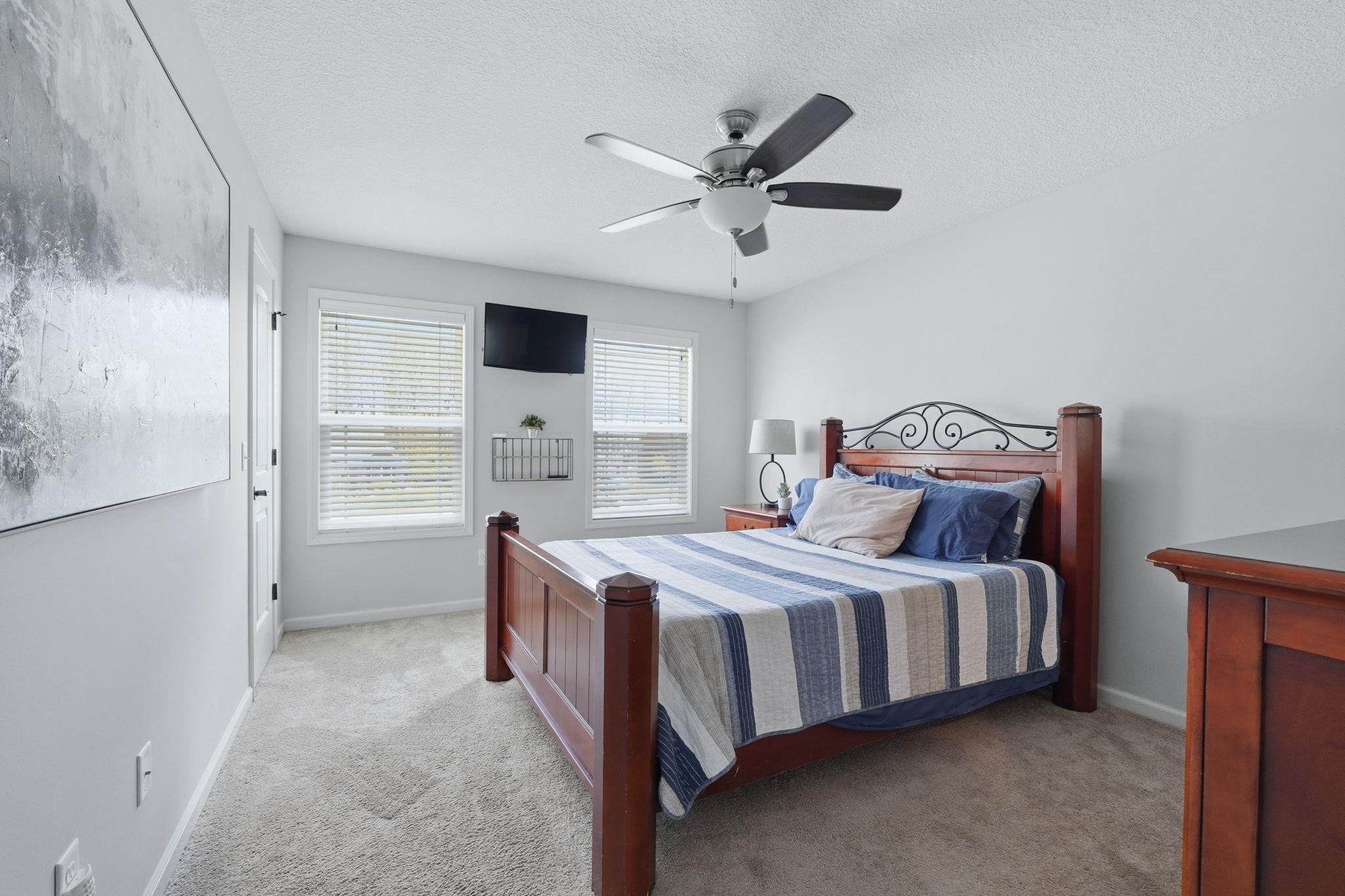 Bedroom featuring light carpet, ceiling fan