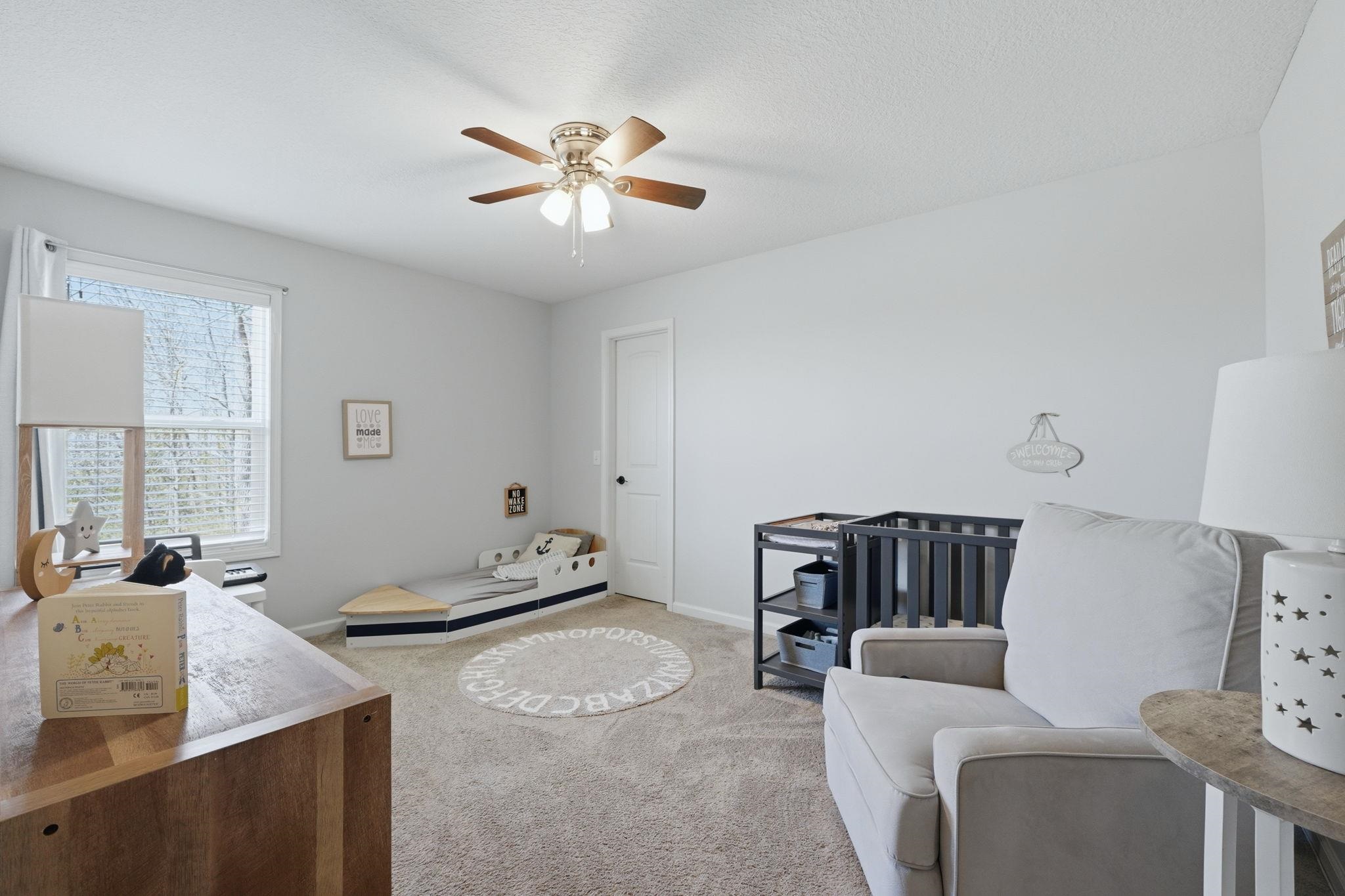 Bedroom featuring light carpet, and ceiling fan