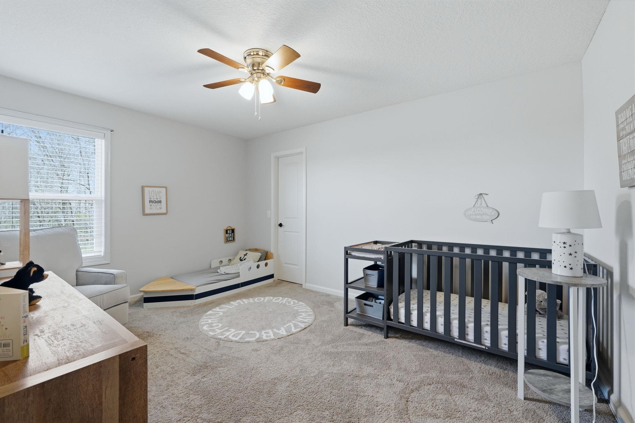 Bedroom featuring light carpet, and a ceiling fan