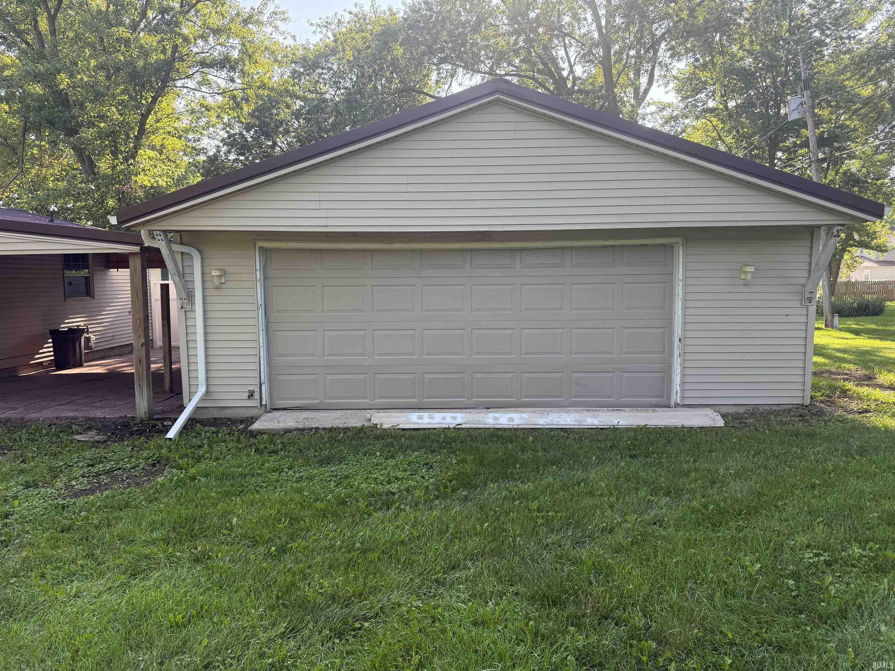 Detached garage with horizontal vinyl siding and a gable roofline
