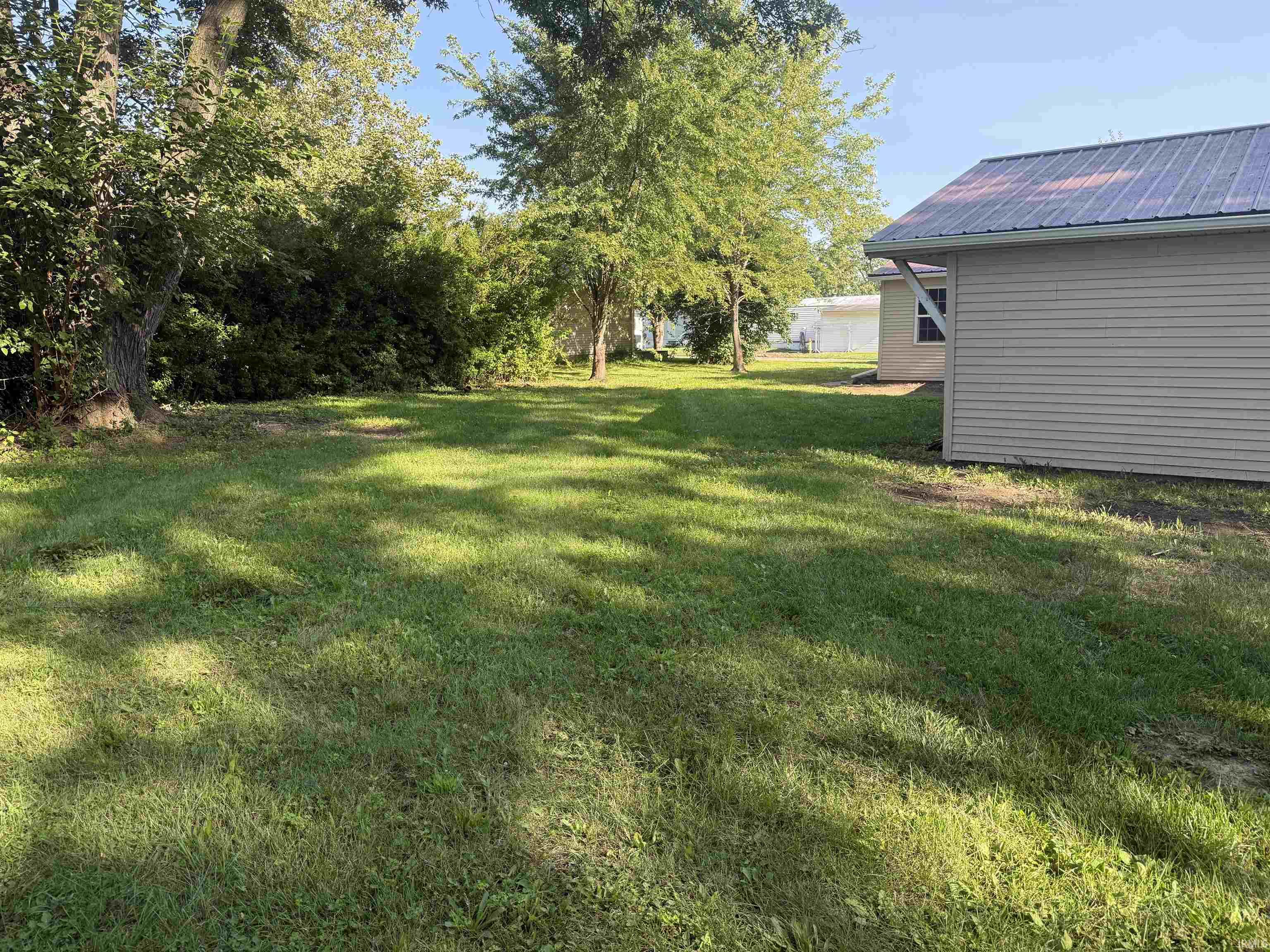 Expansive grassy yard with mature trees