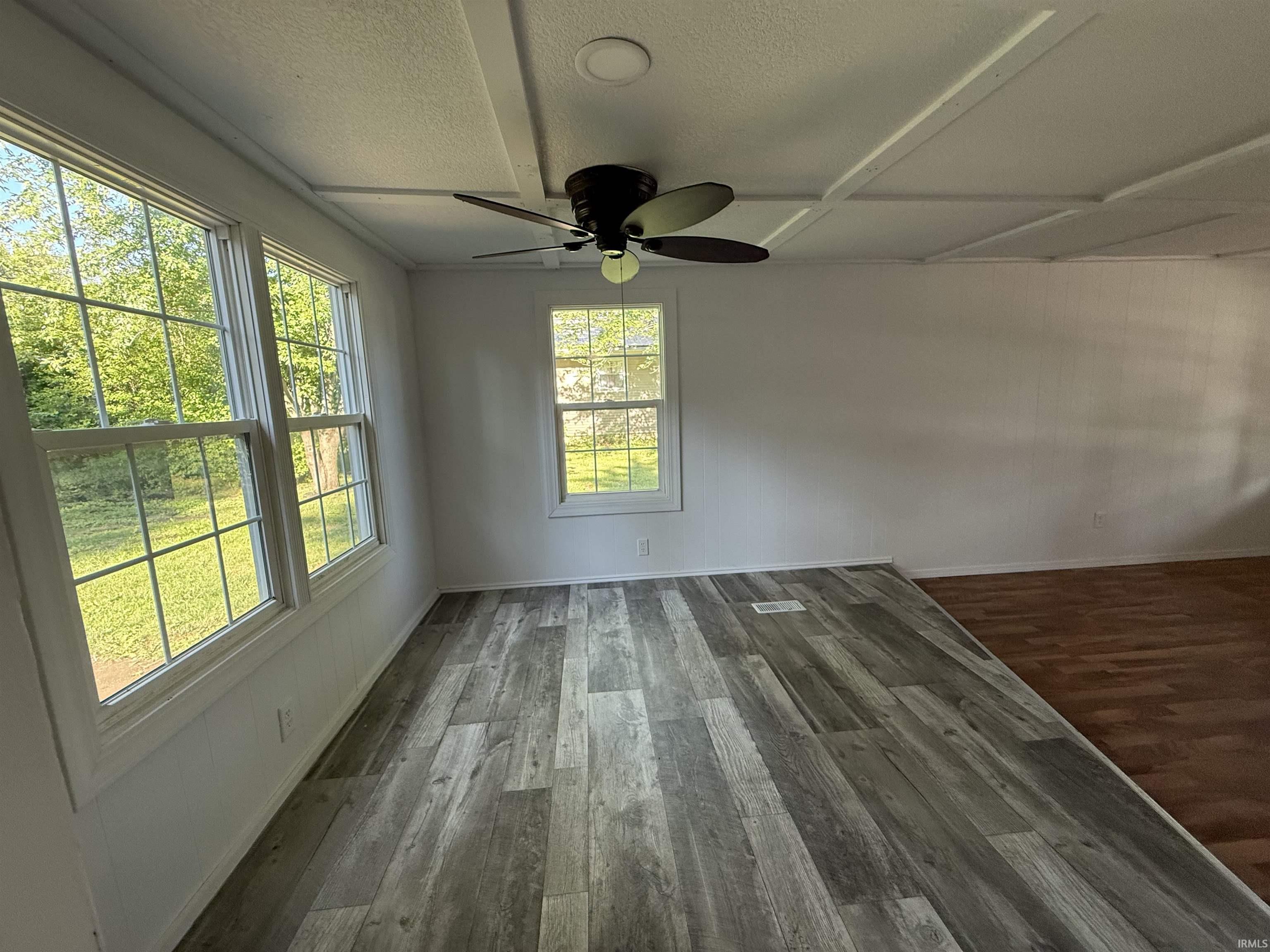 Interior space featuring a dark-toned ceiling fan, recessed lighting, and wood-finish flooring