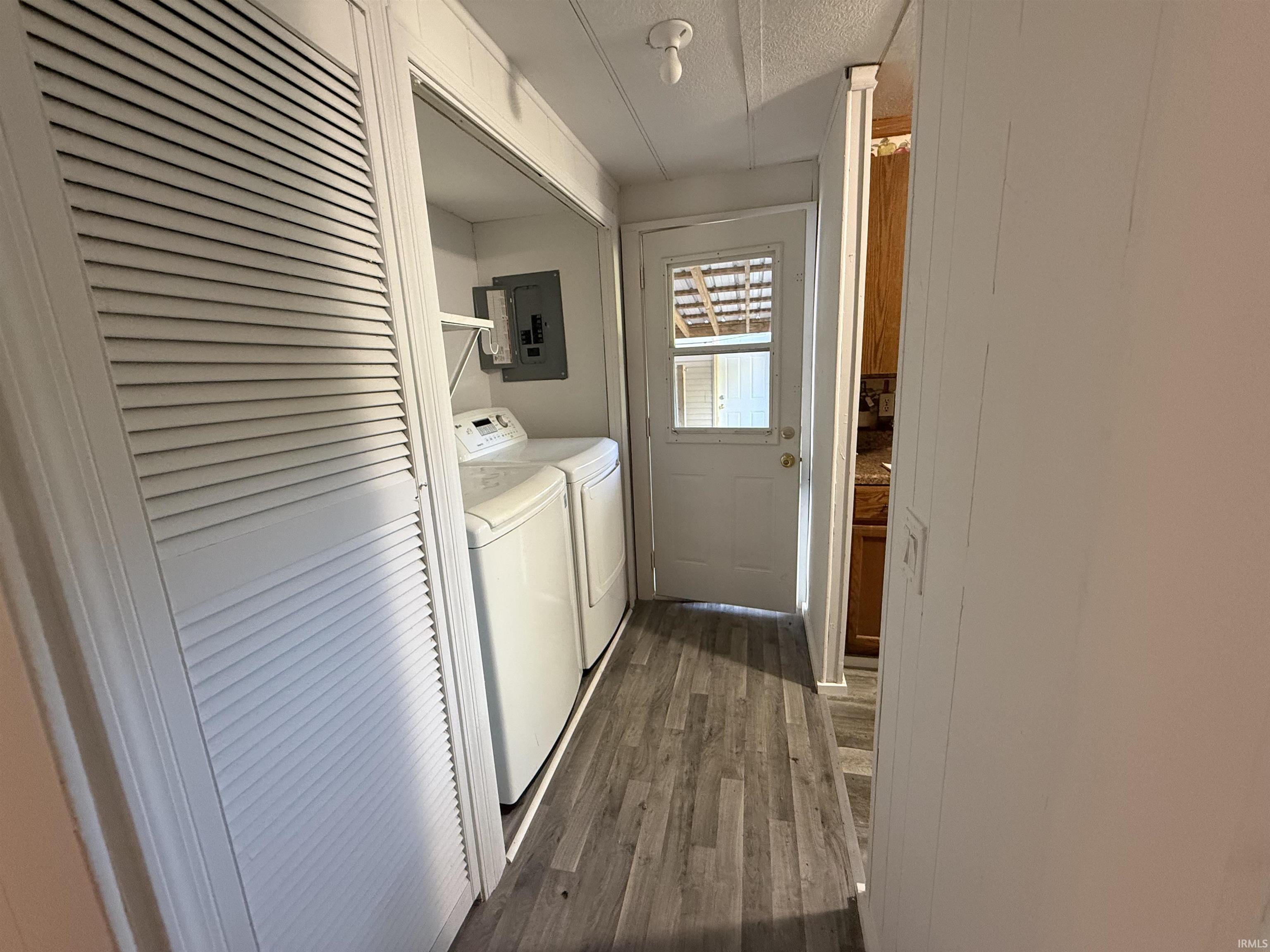 Utility area featuring wood-finish flooring and a white louvered bifold door