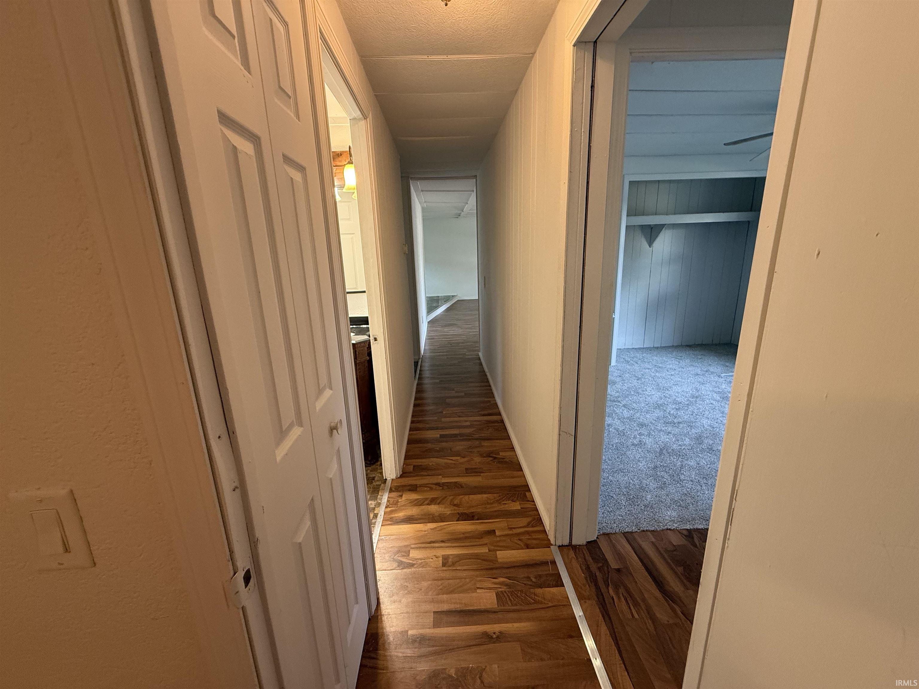 Hallway featuring wood-finish flooring