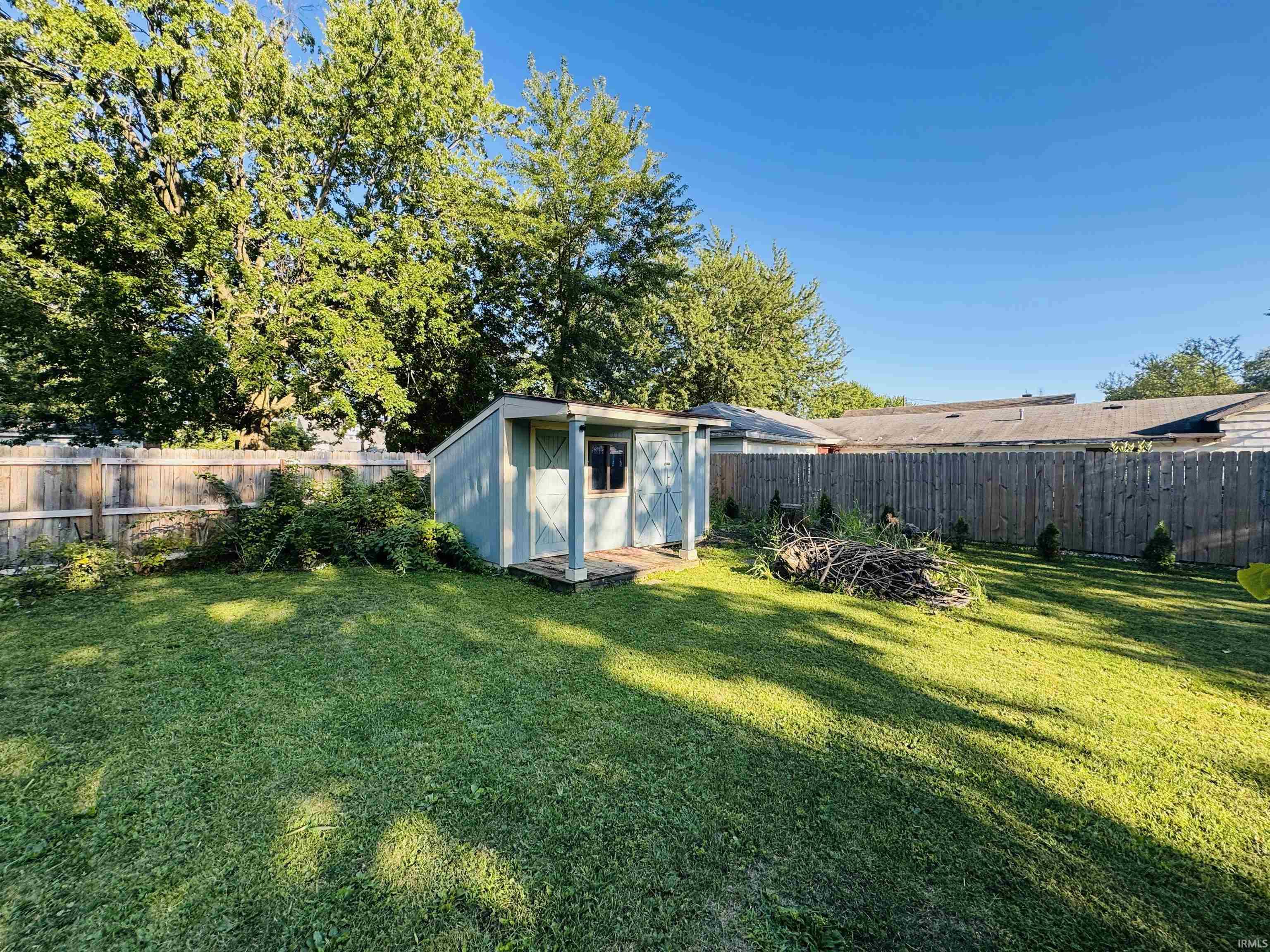 Spacious backyard featuring a utility shed and mature perimeter fencing