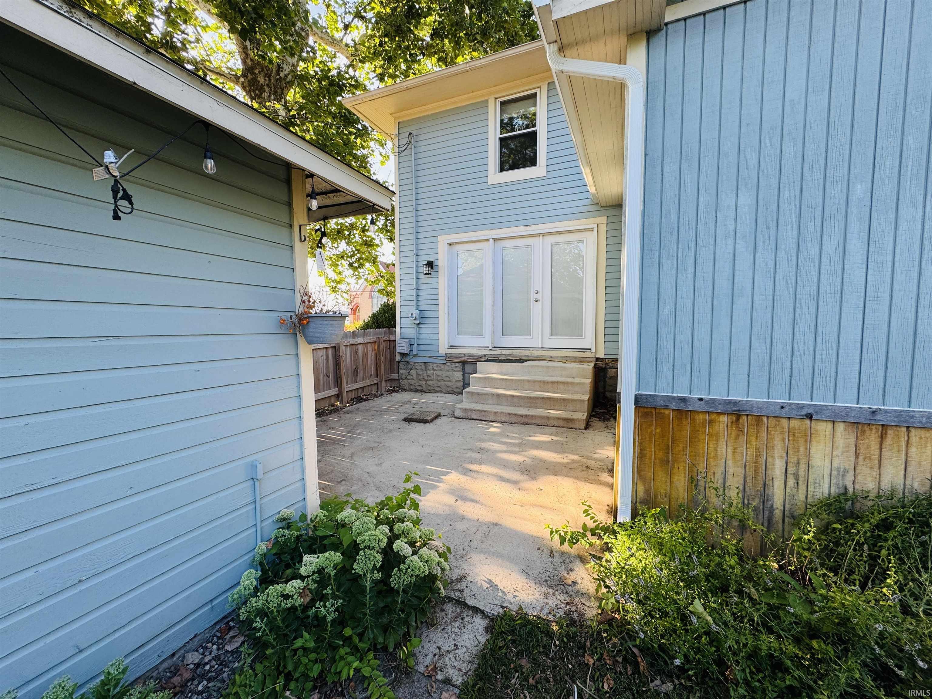 Patio area featuring concrete steps and a privacy fence