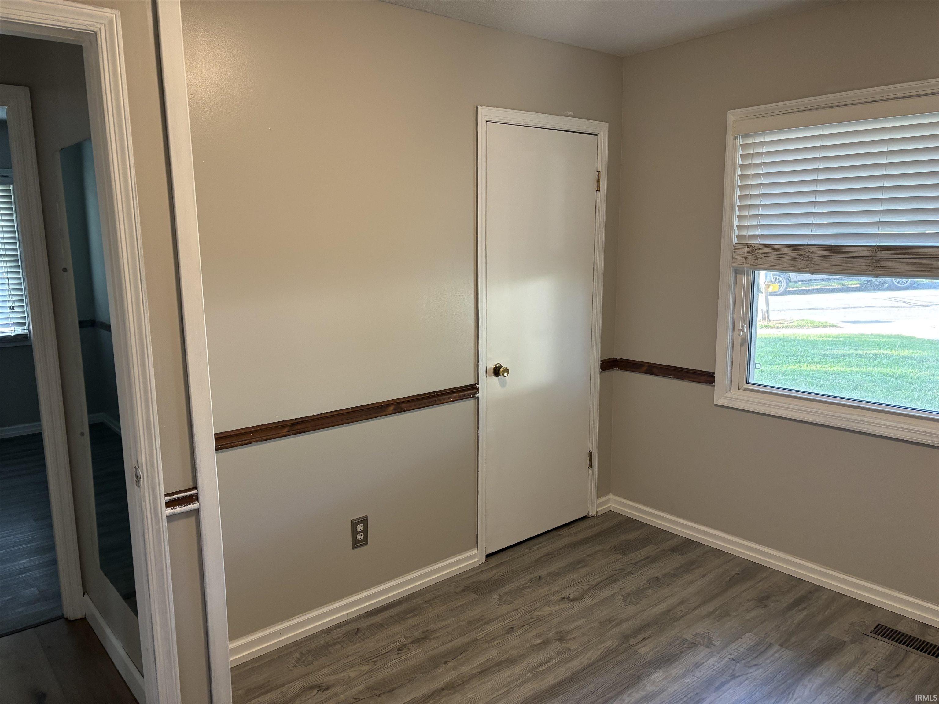 Interior room featuring light neutral wall paint with a wood-finish chair rail
