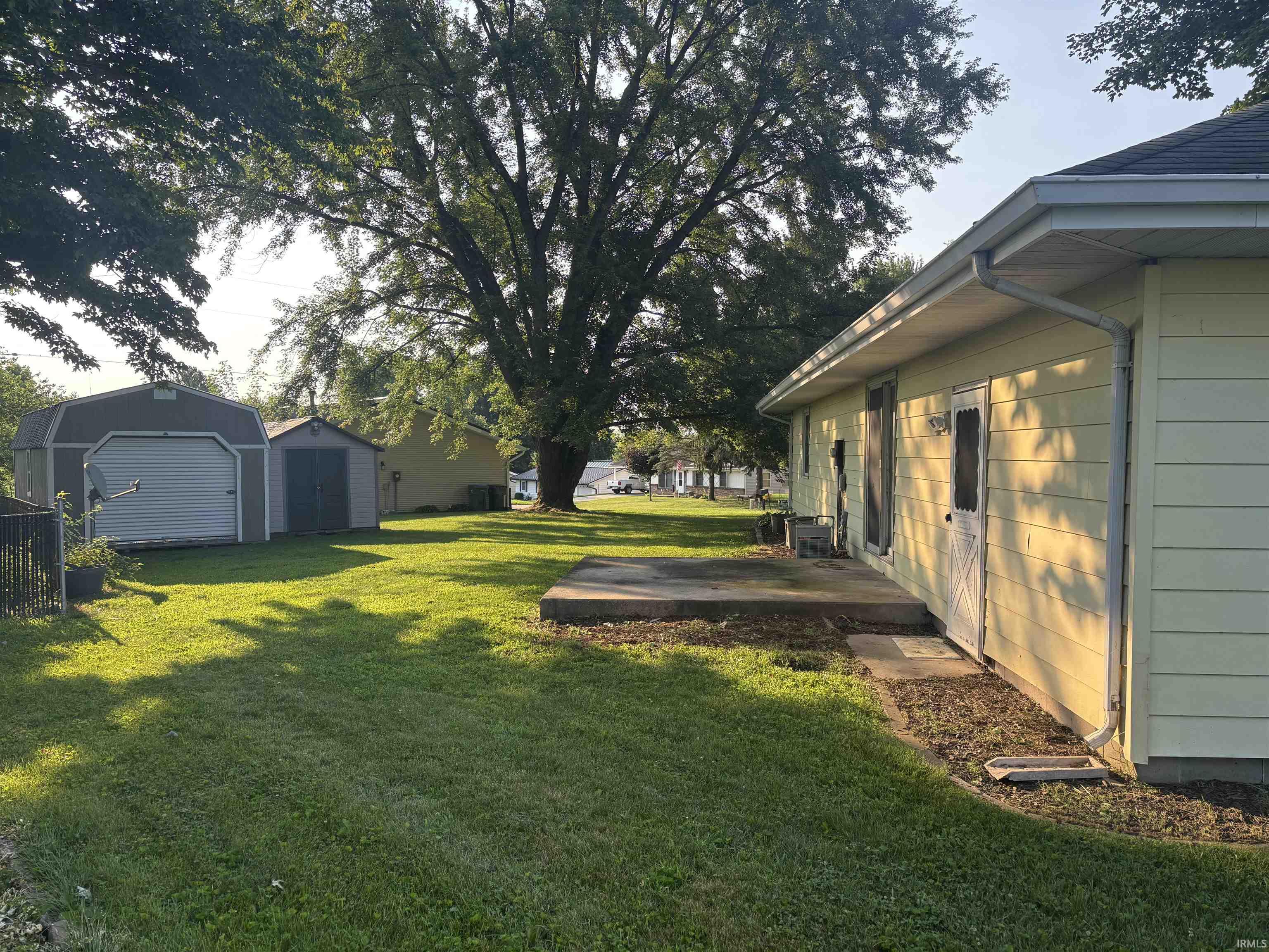Expansive green lawn with a concrete patio