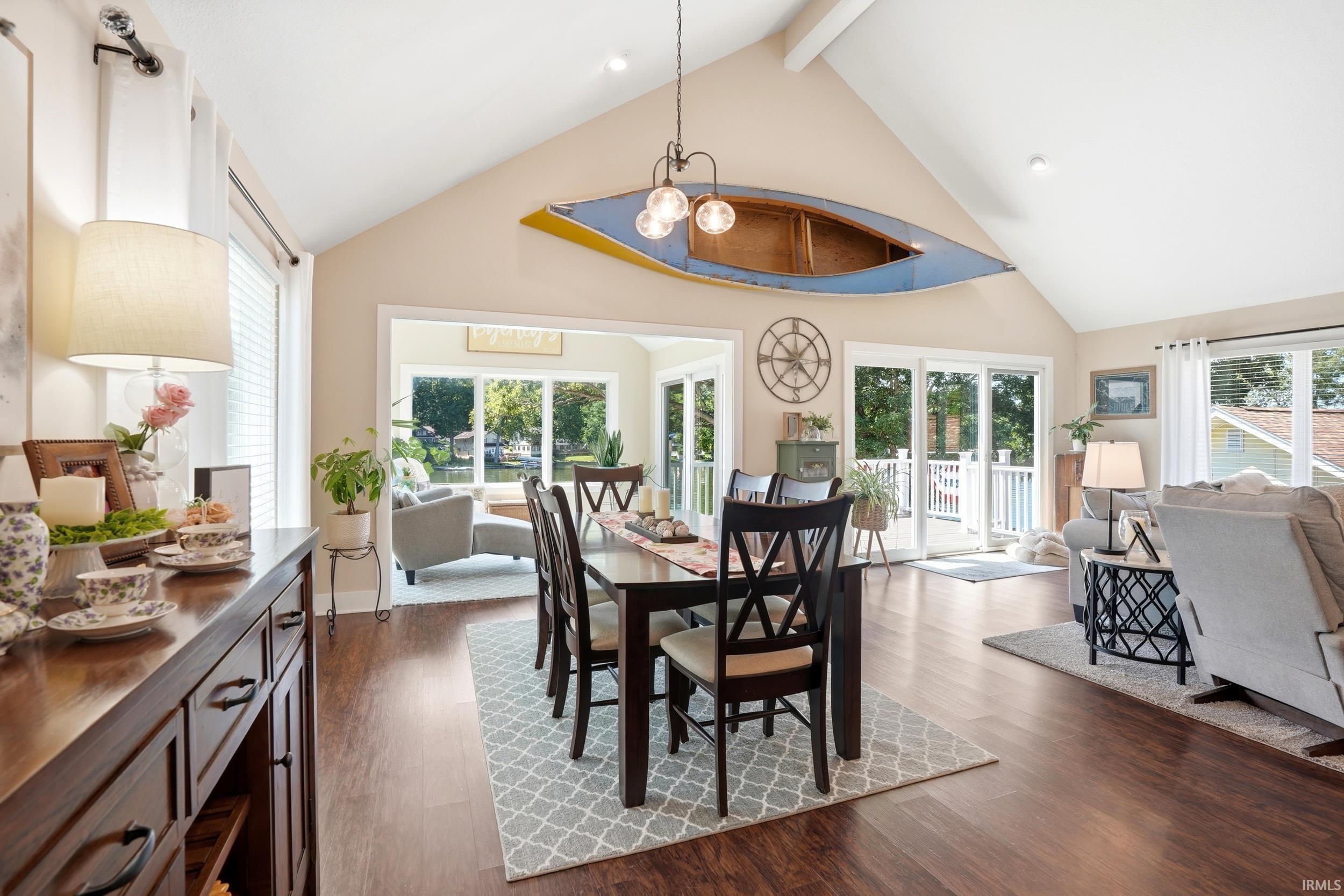 Open-concept living space anchored by a vaulted ceiling with skylights and a suspended wood-finish accent feature