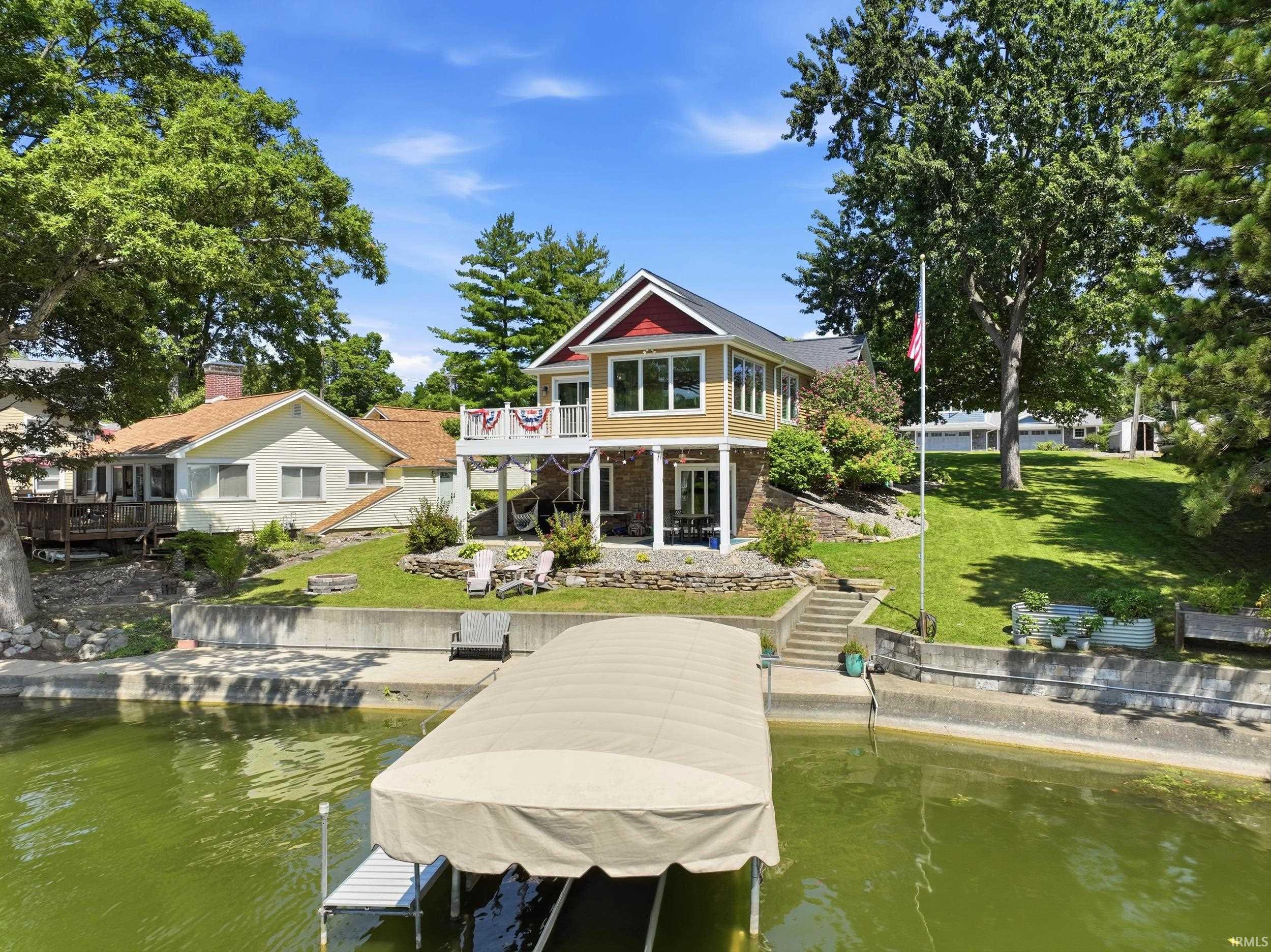 Waterfront property featuring a two-story residence with a covered boat dock and mooring post