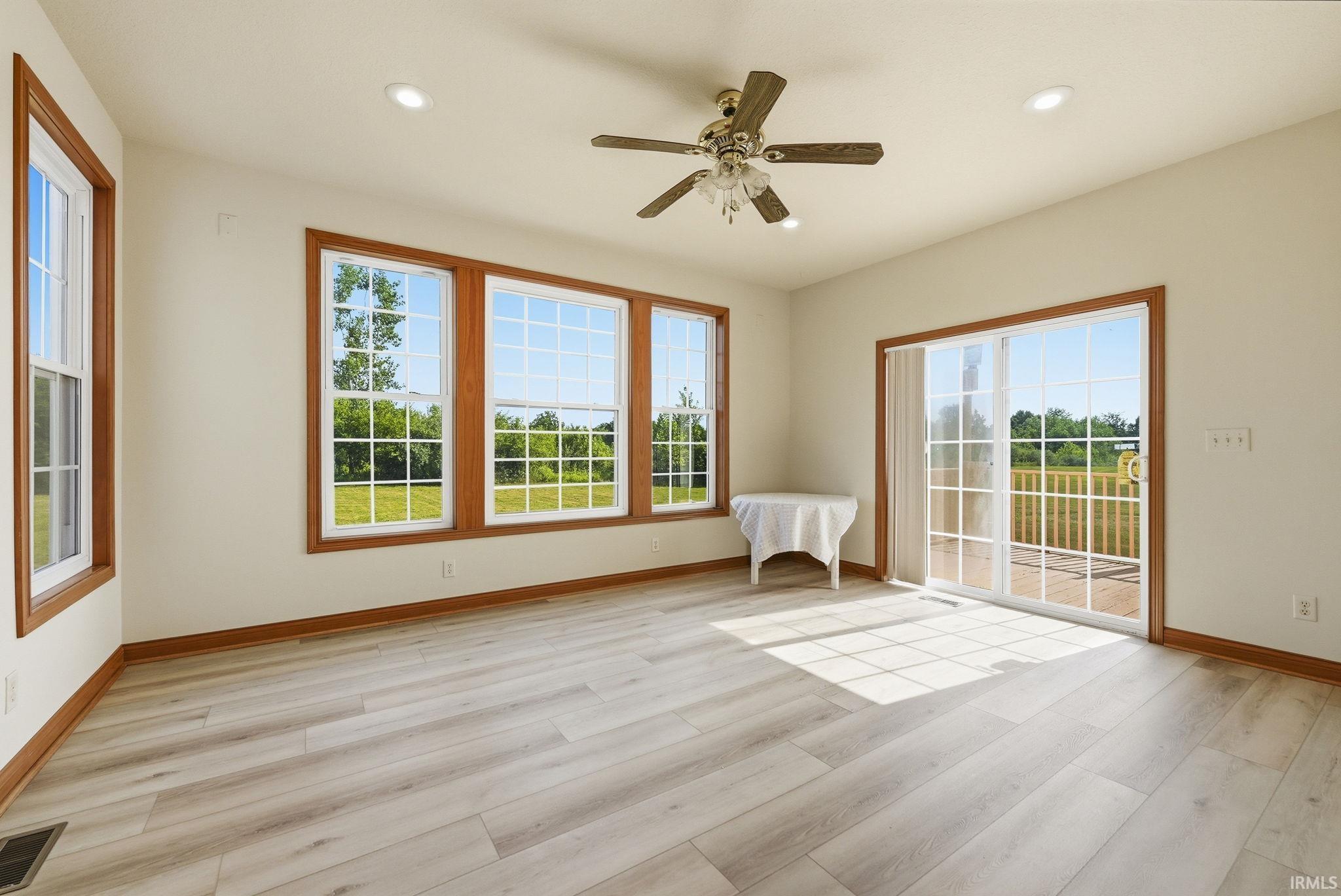 Bright living area featuring wood-finish flooring, recessed lighting, and a ceiling fan