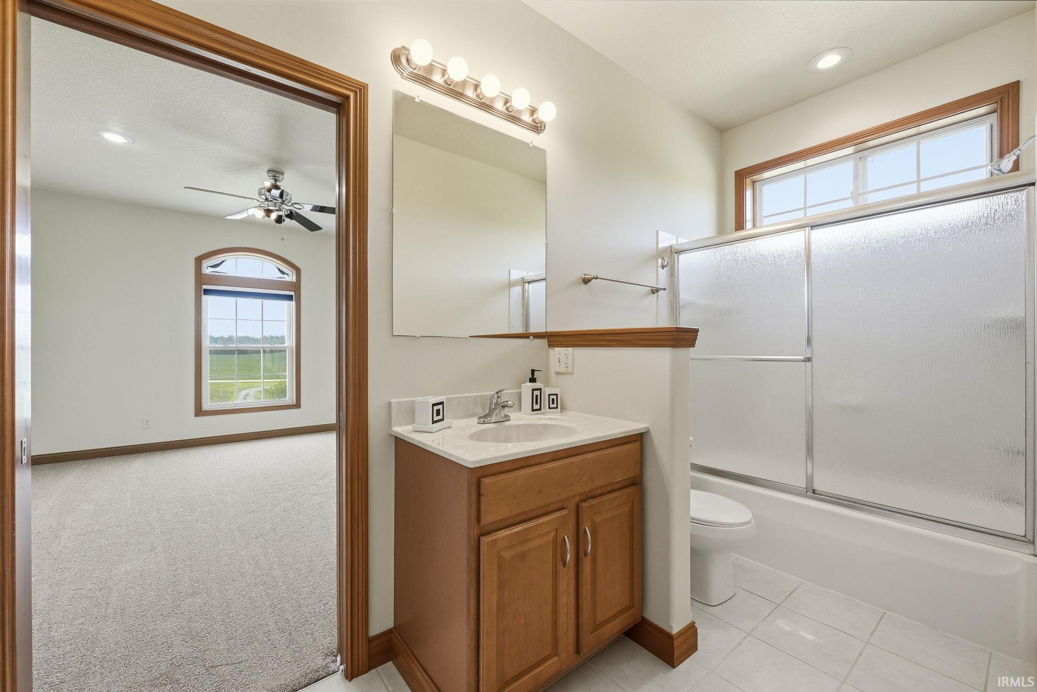Bathroom featuring a single vanity with a light-colored countertop and wood-finish cabinetry