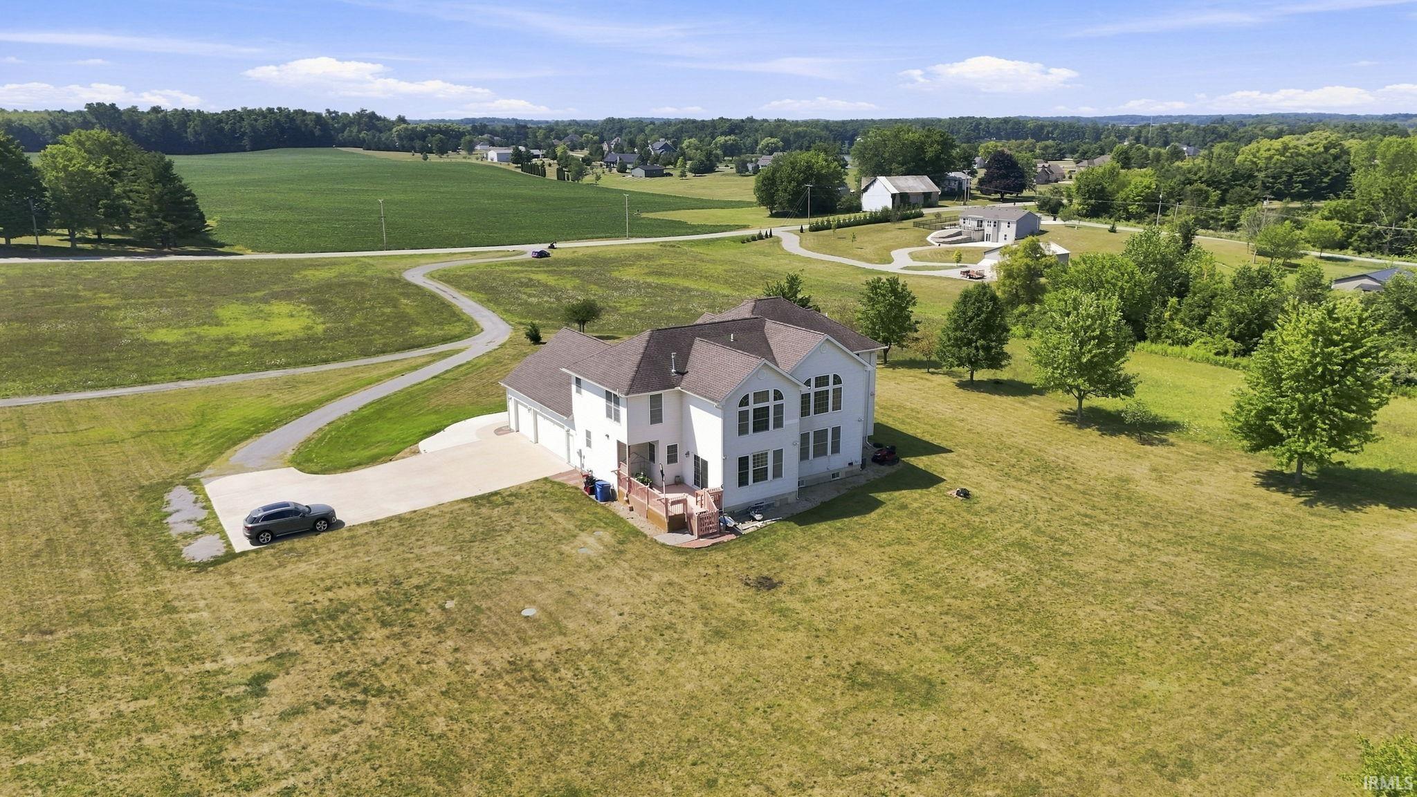 White-sided residence featuring multiple gables and a multi-car garage