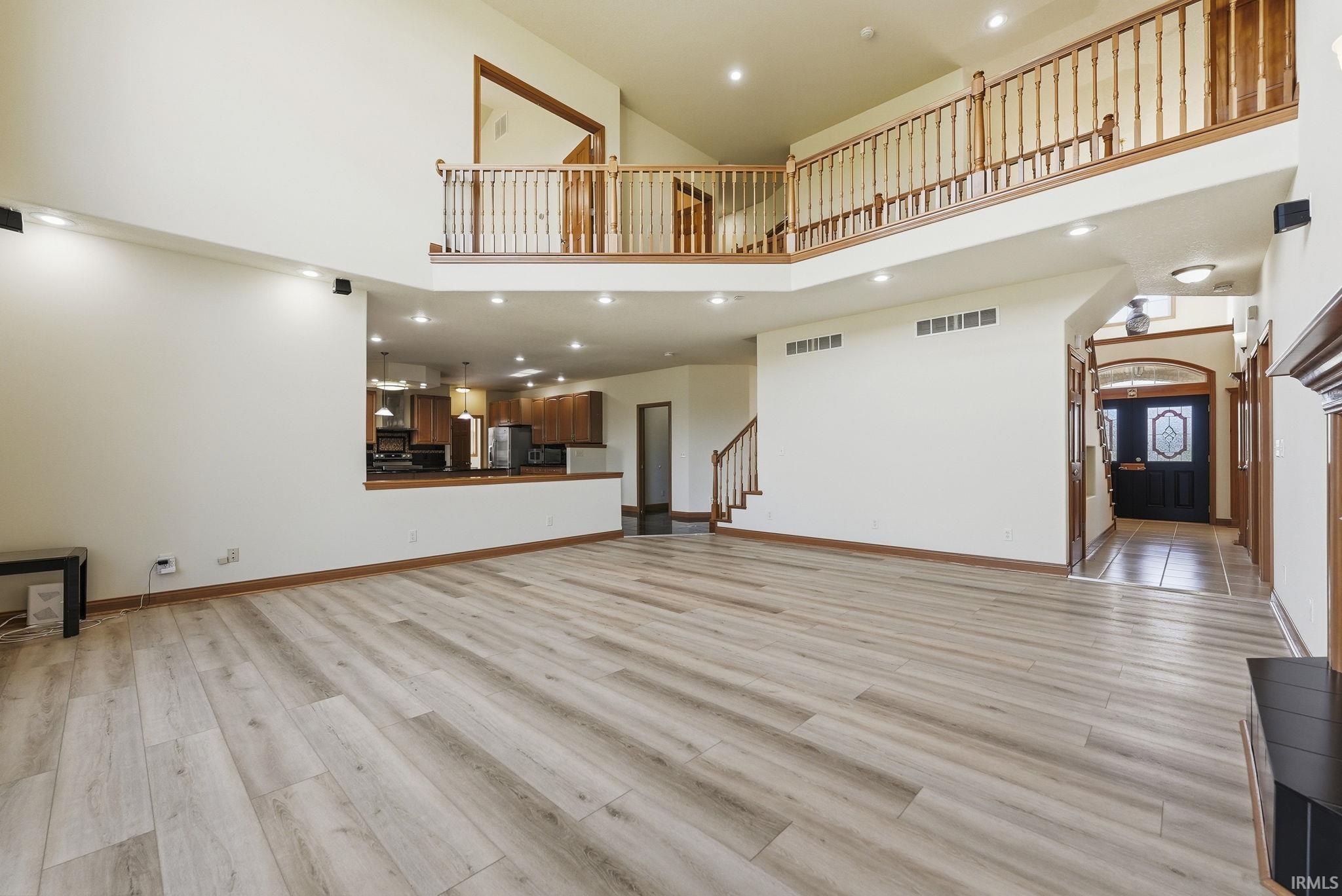 Expansive great room featuring wood-finish flooring and a two-story ceiling