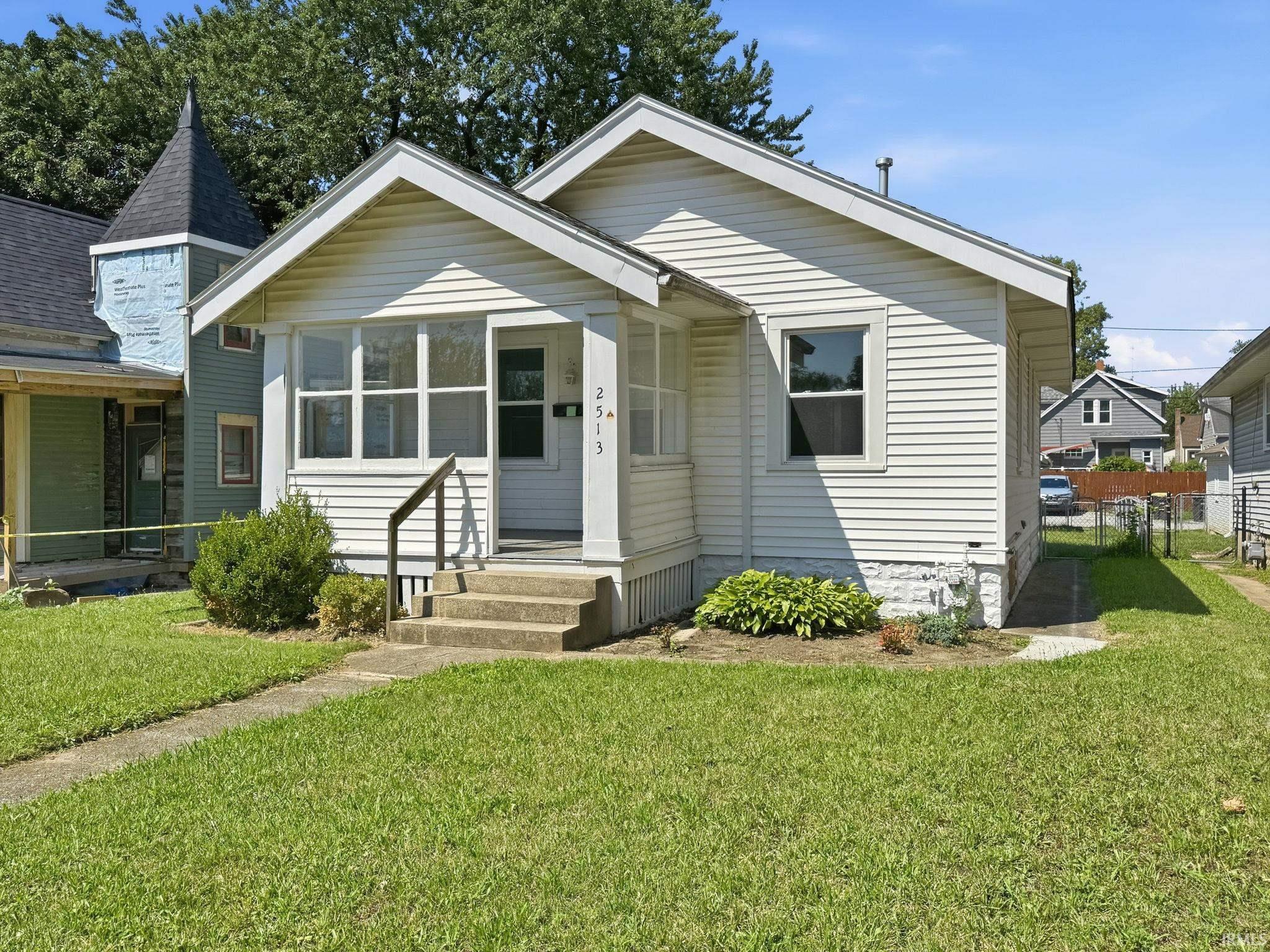 White horizontal siding exterior with a covered porch and concrete steps