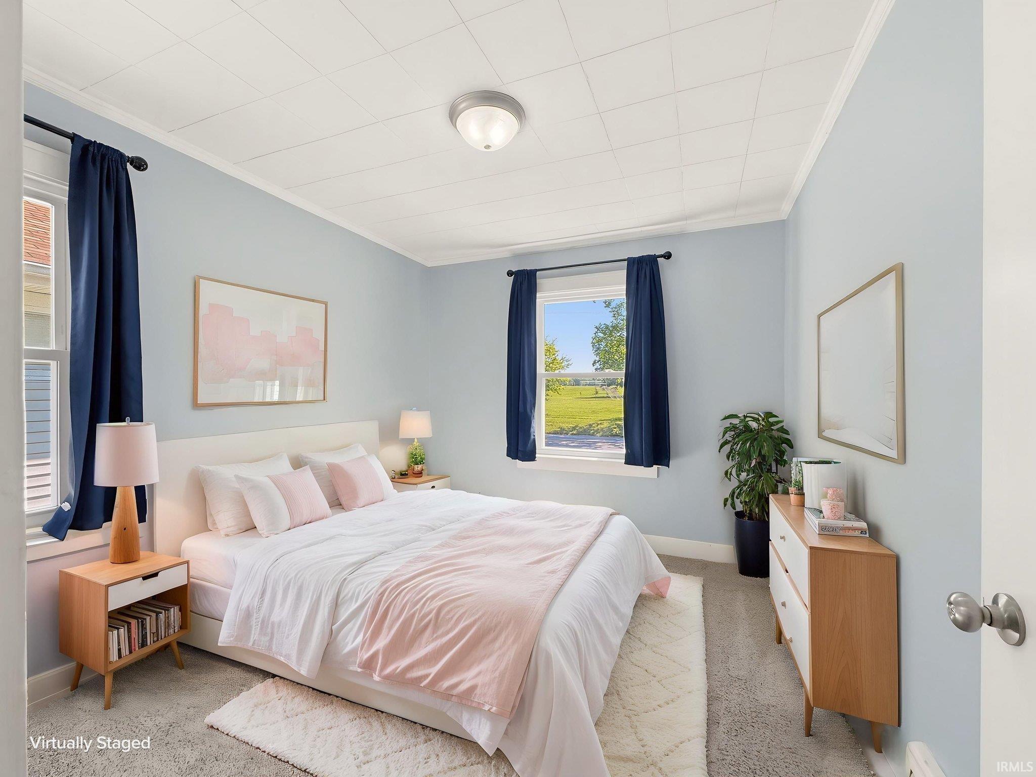 Light blue painted walls with white trim, a ceiling-mounted light fixture, and two windows providing natural light