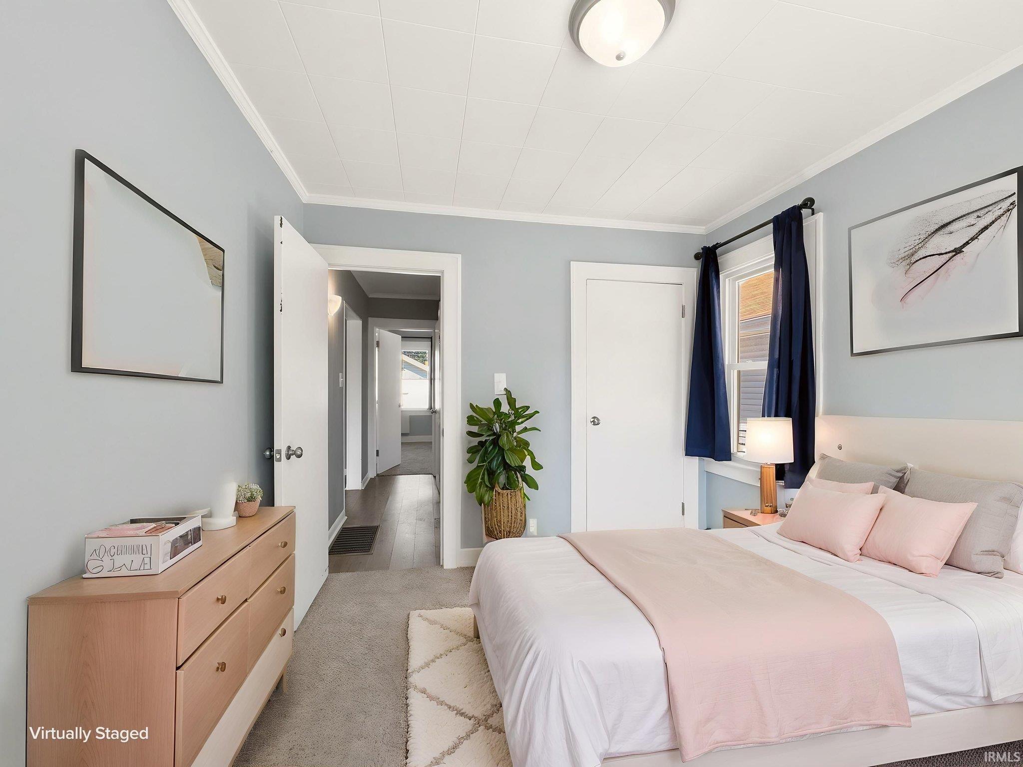 Bedroom featuring light blue walls, white trim, and a white paneled ceiling