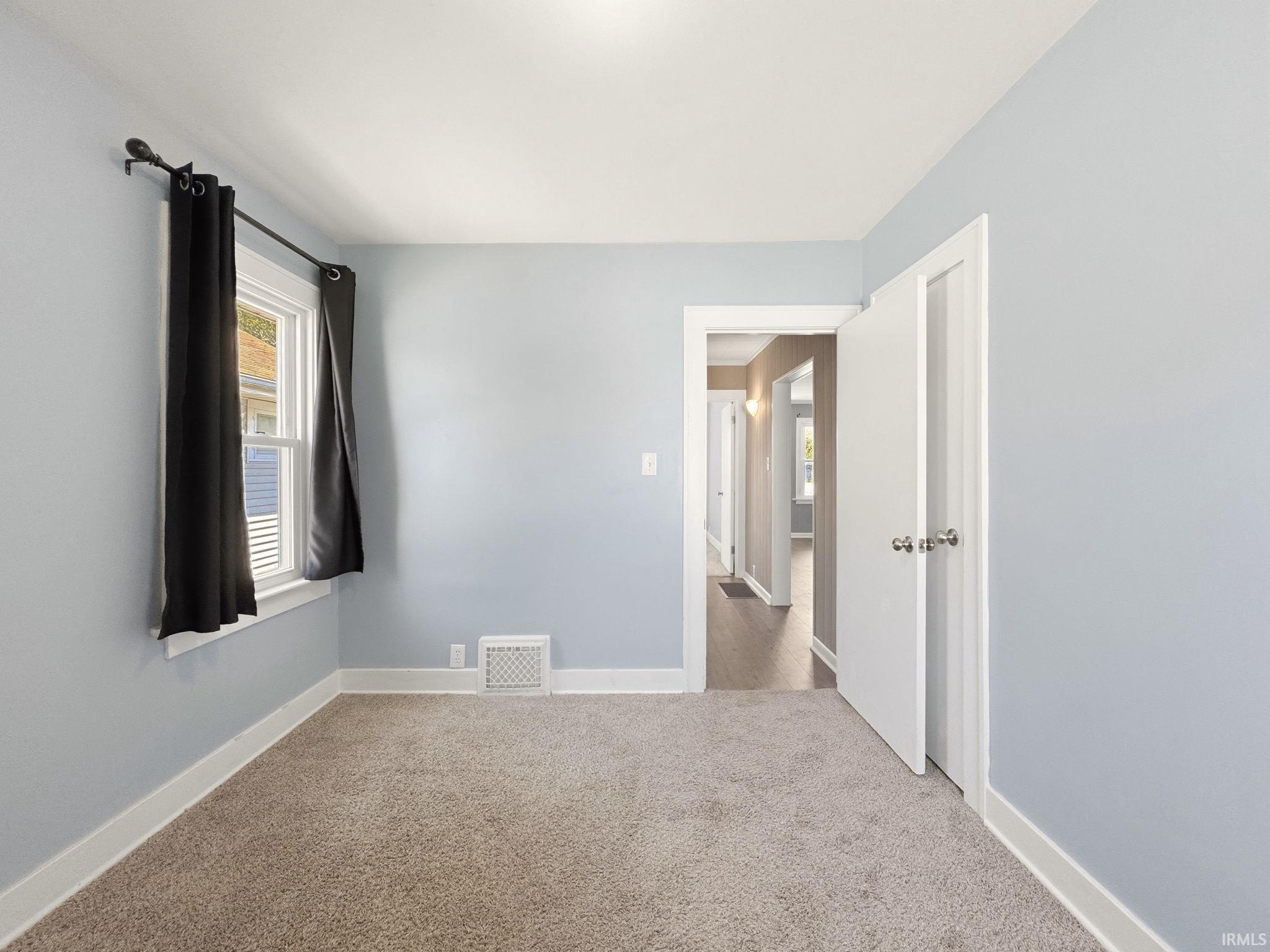 Carpeted room with light blue walls and white trim