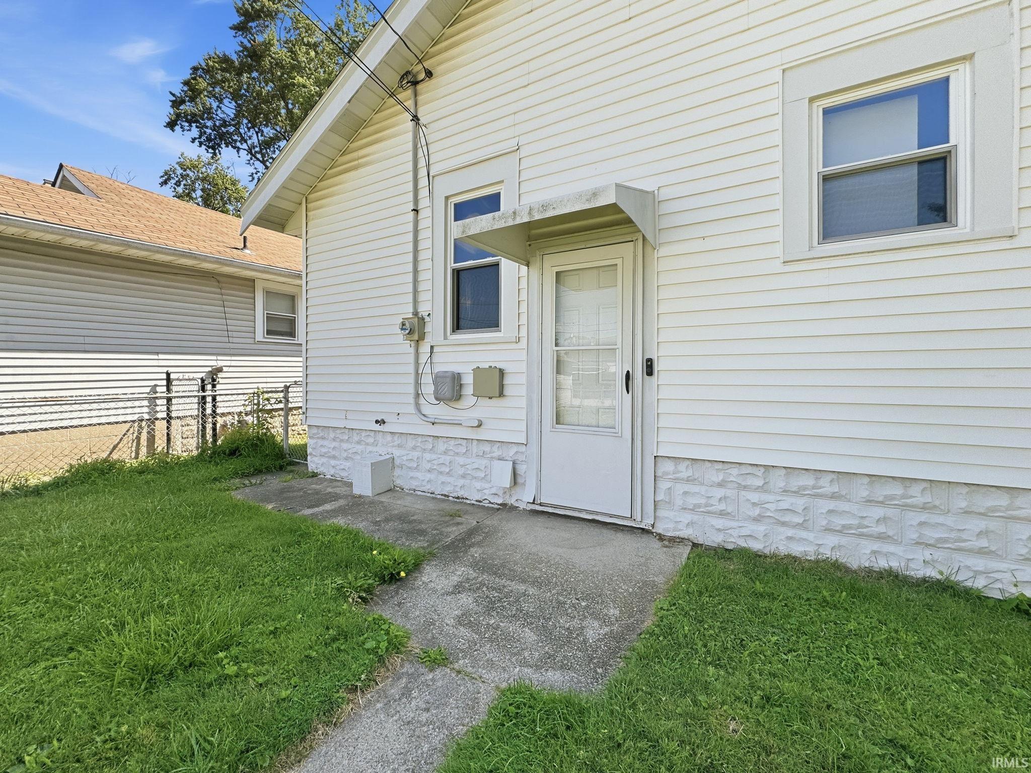 White vinyl siding exterior with a concrete patio