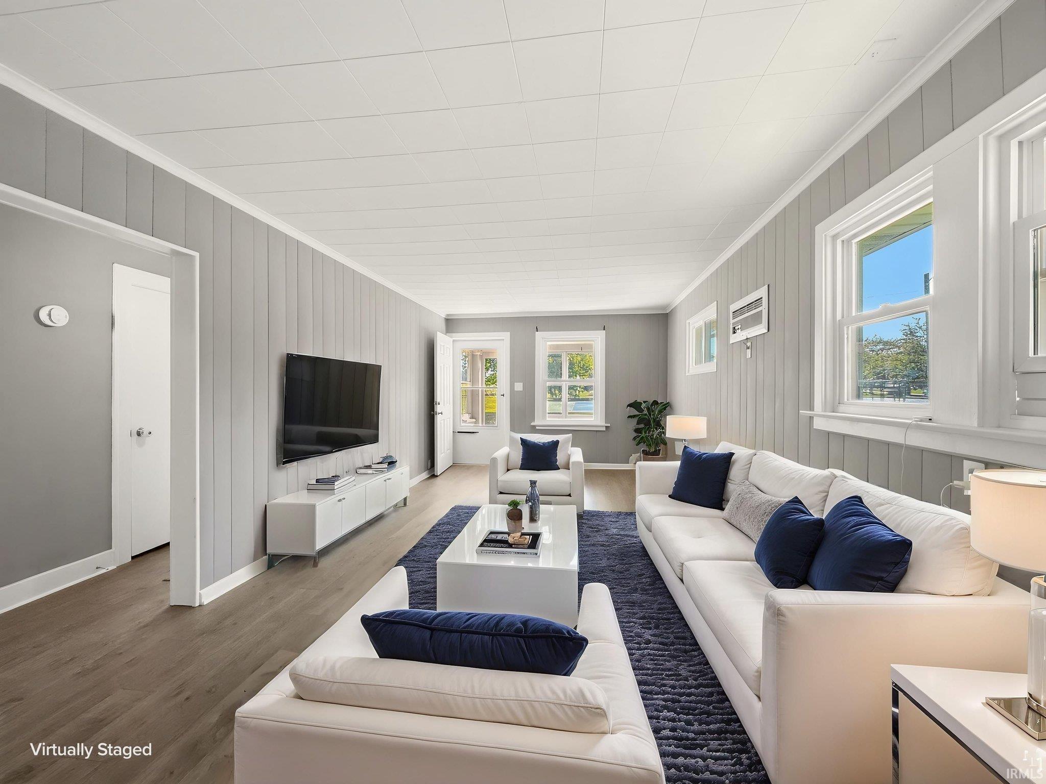 Bright living area featuring wood-finish flooring and paneled walls