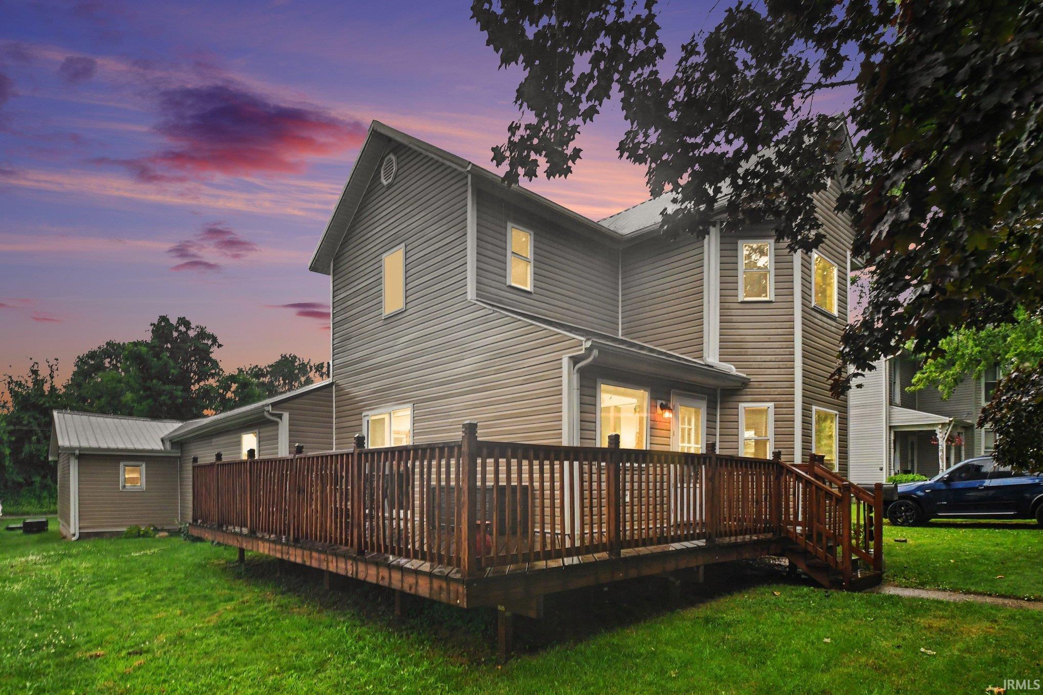 Expansive rear wood deck with railing and stairs