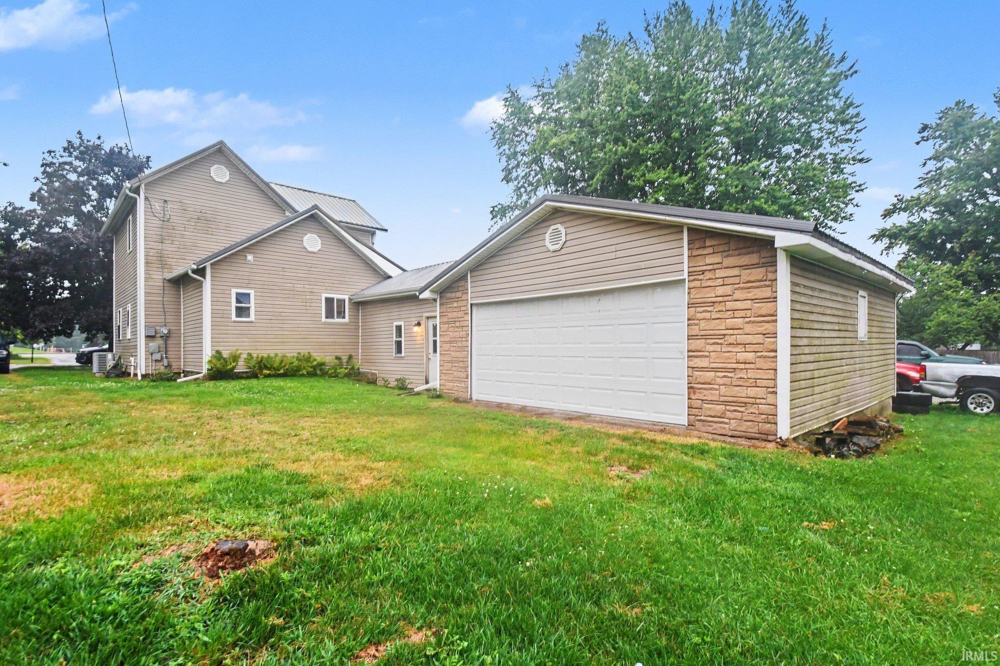 Attached single-car garage featuring stacked stone facade and horizontal siding