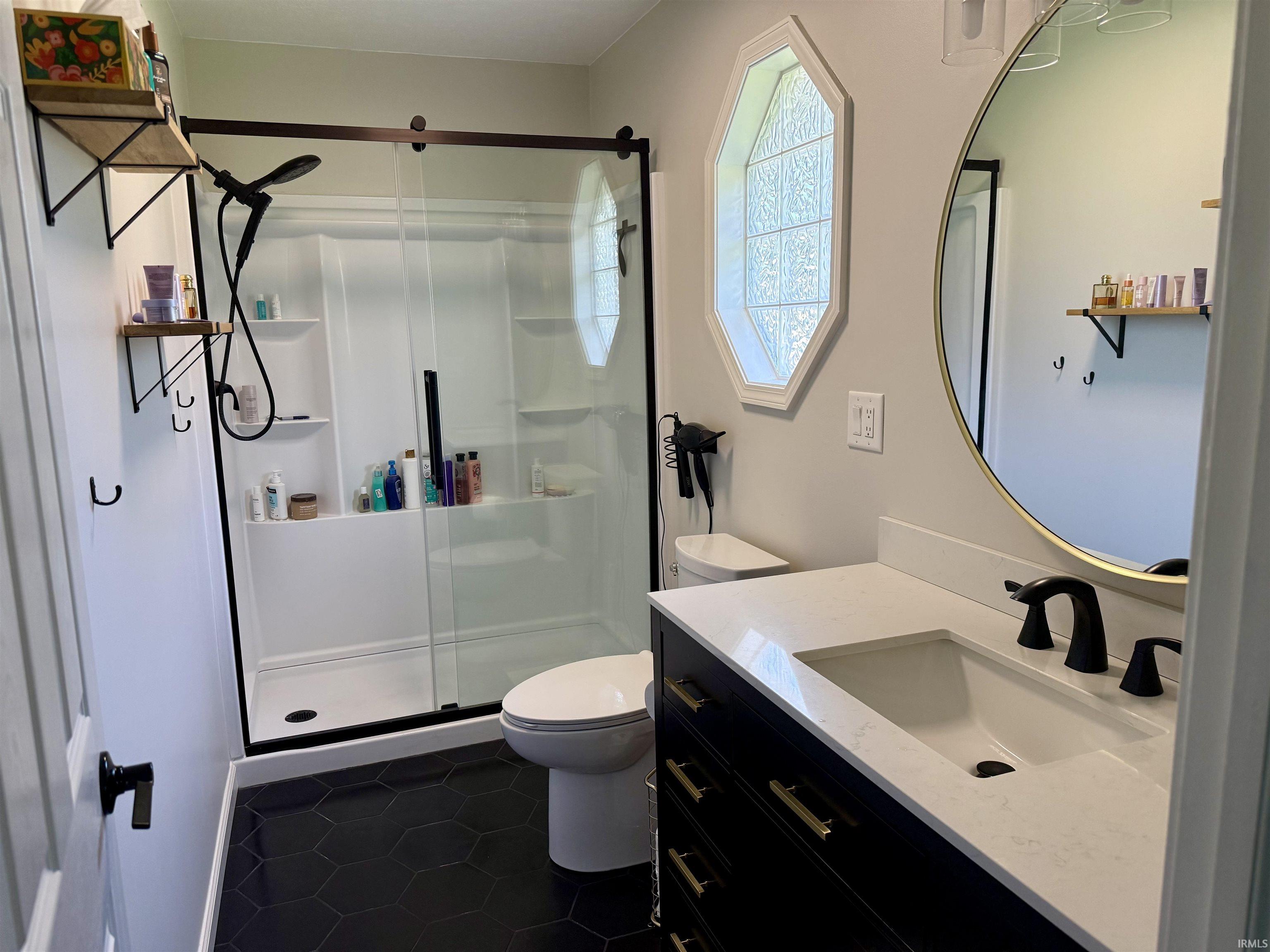 Bathroom featuring a black hexagon tile floor and a vanity with a white countertop