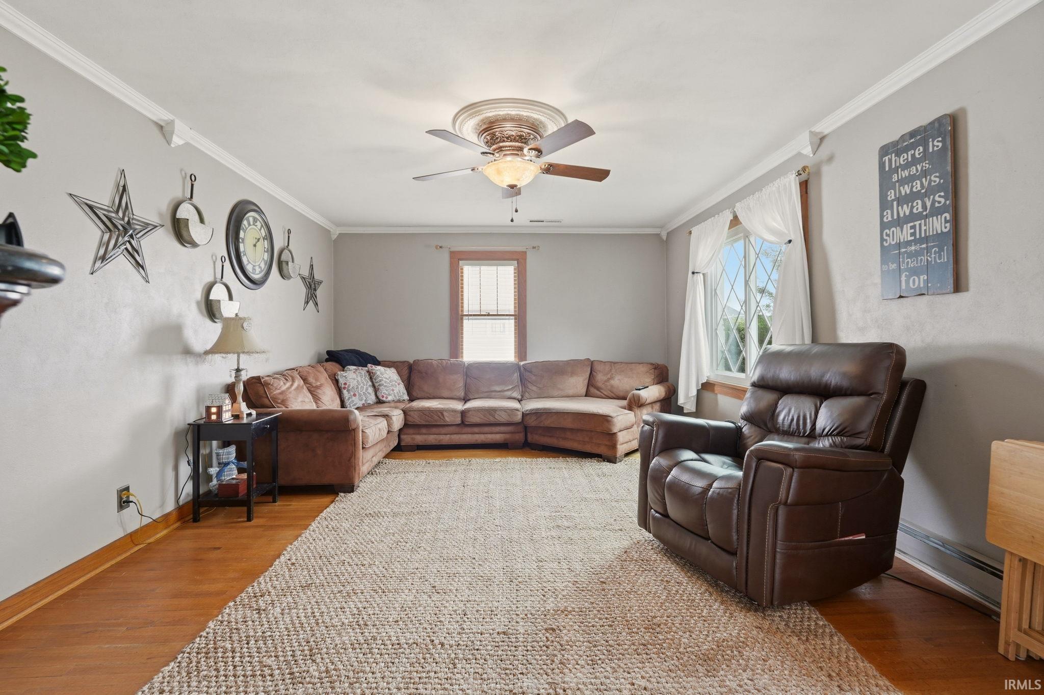 Living area featuring wood-finish flooring, light gray wall paint, and white crown molding