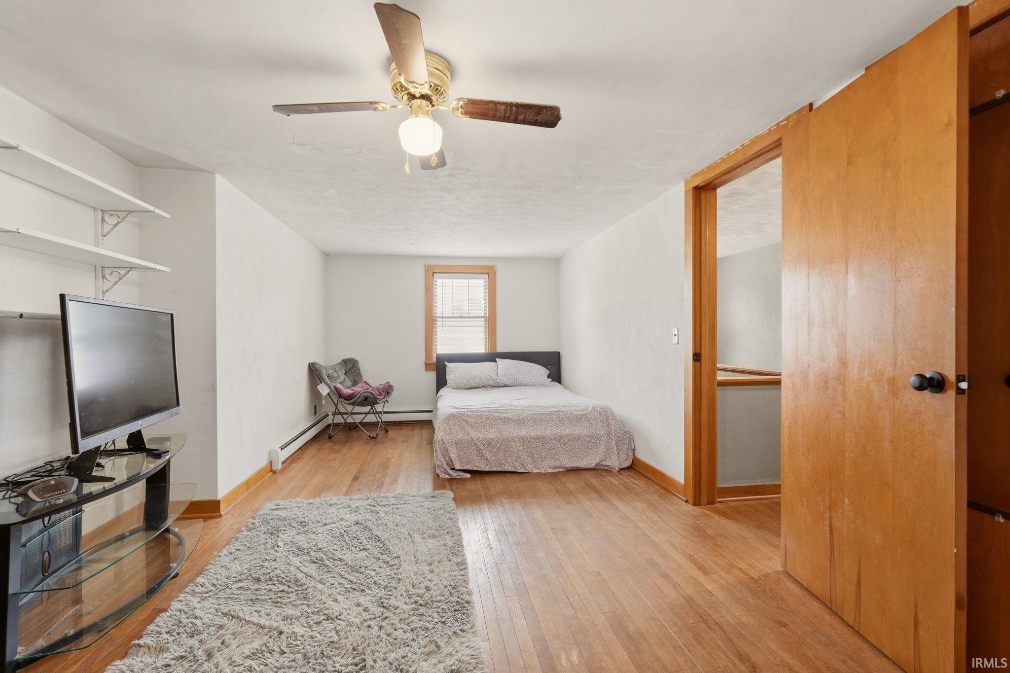 Spacious room featuring wood-finish flooring and a ceiling fan