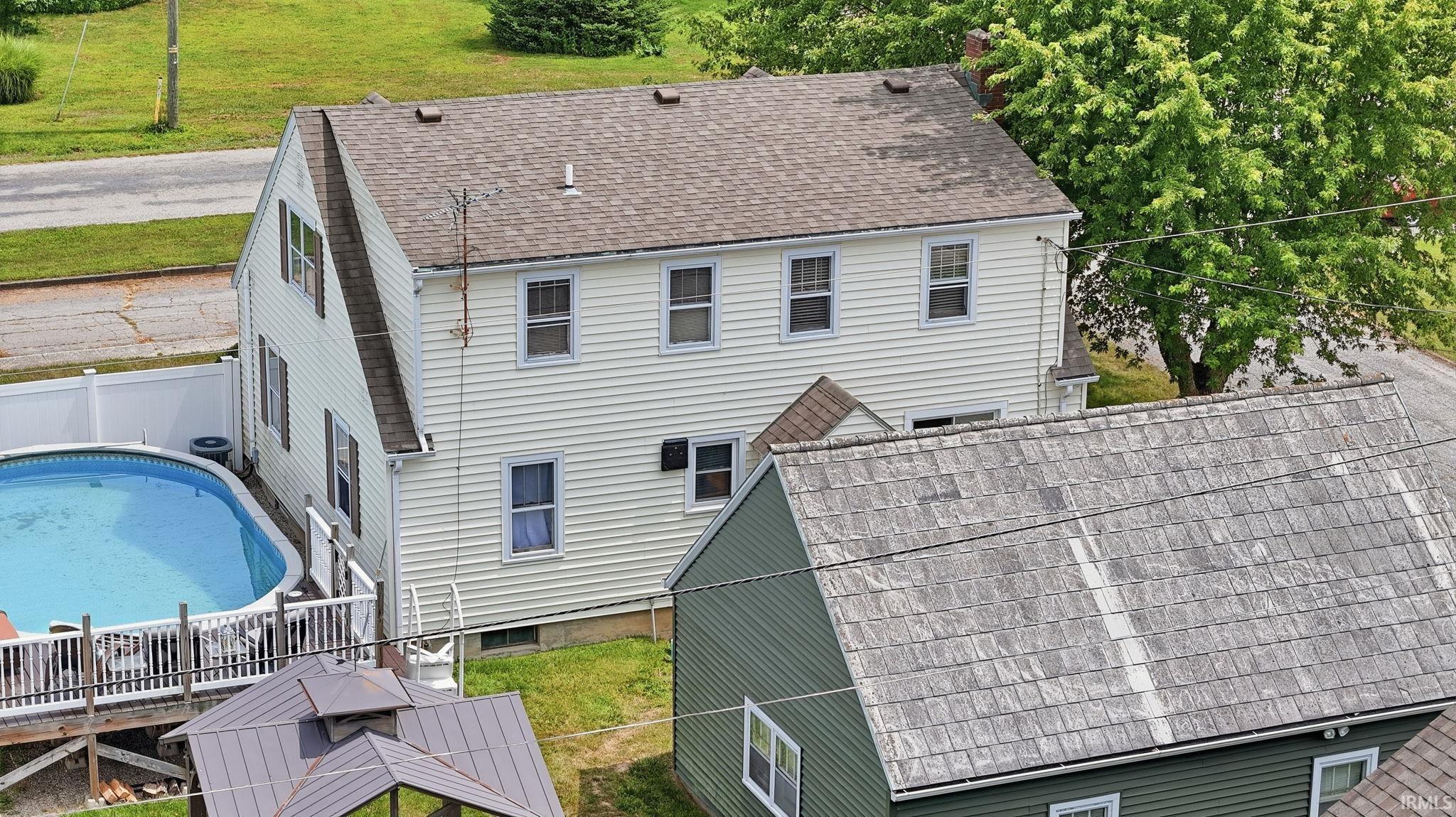 Two-story residence featuring white siding and a brown shingle roof