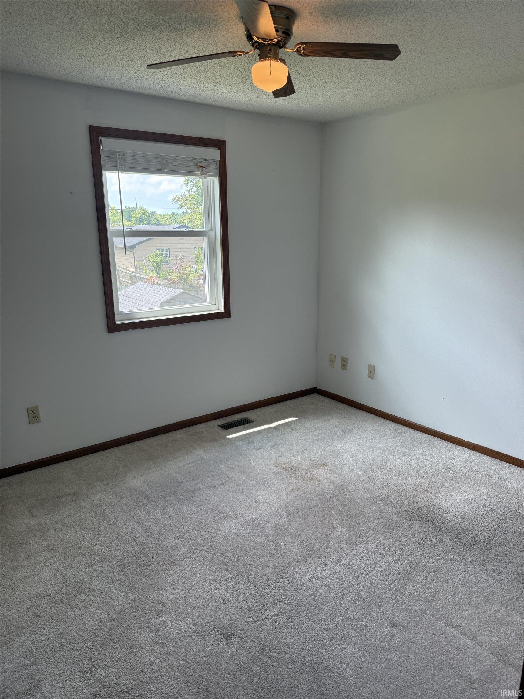 Carpeted room featuring a ceiling fan with integrated lighting, a single window with blinds, and white walls