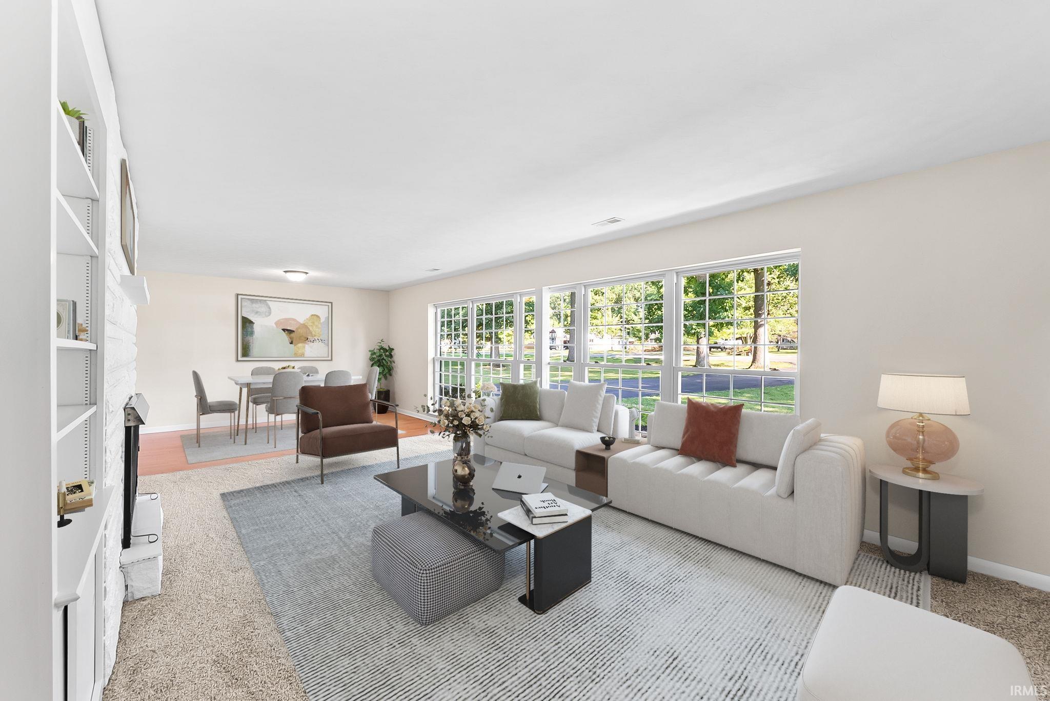 Expansive window wall, built-in shelving, fireplace, wood-finish flooring, and recessed lighting