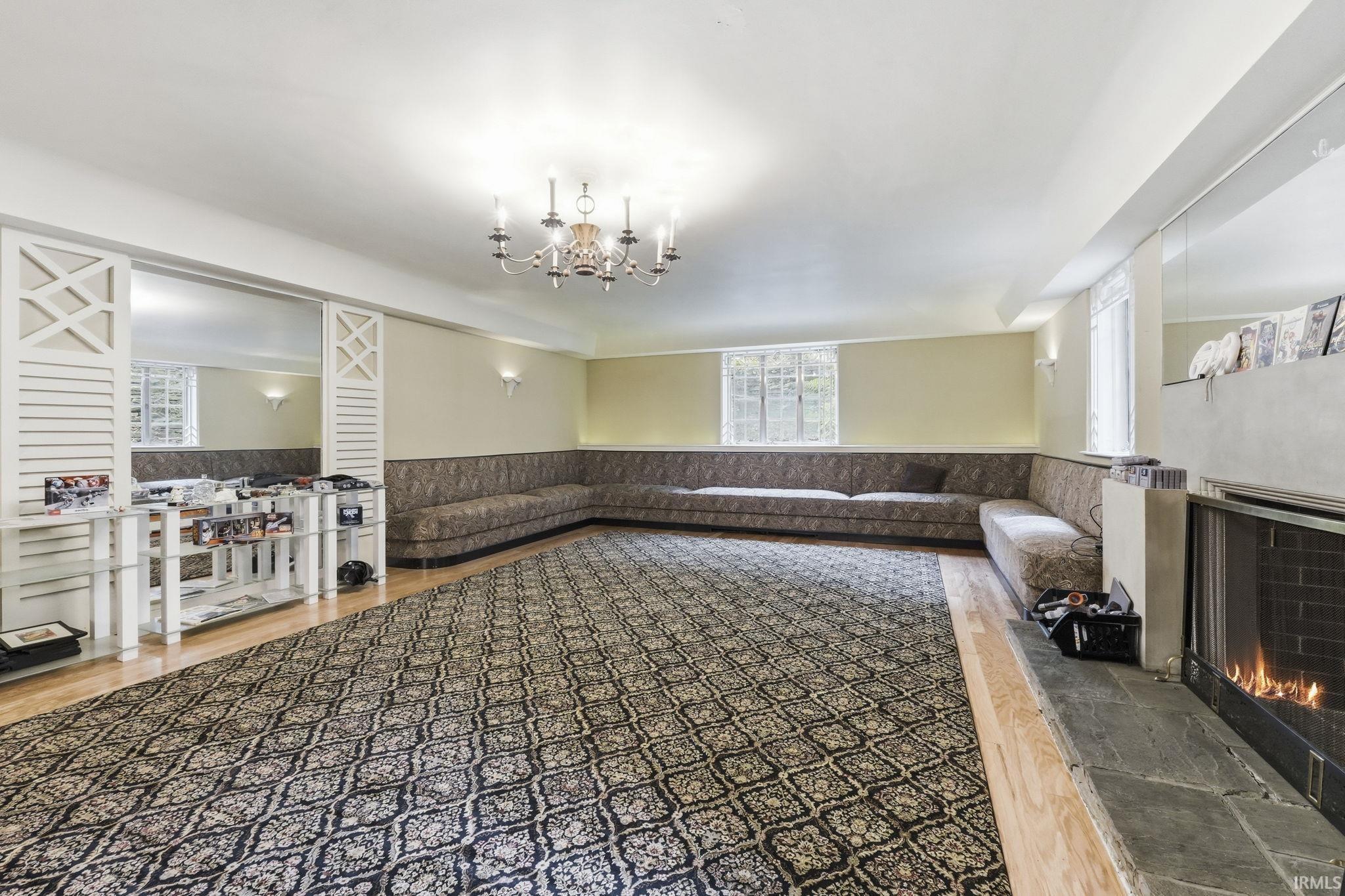Spacious room with a built-in fireplace, wall sconce lighting, and a chandelier
