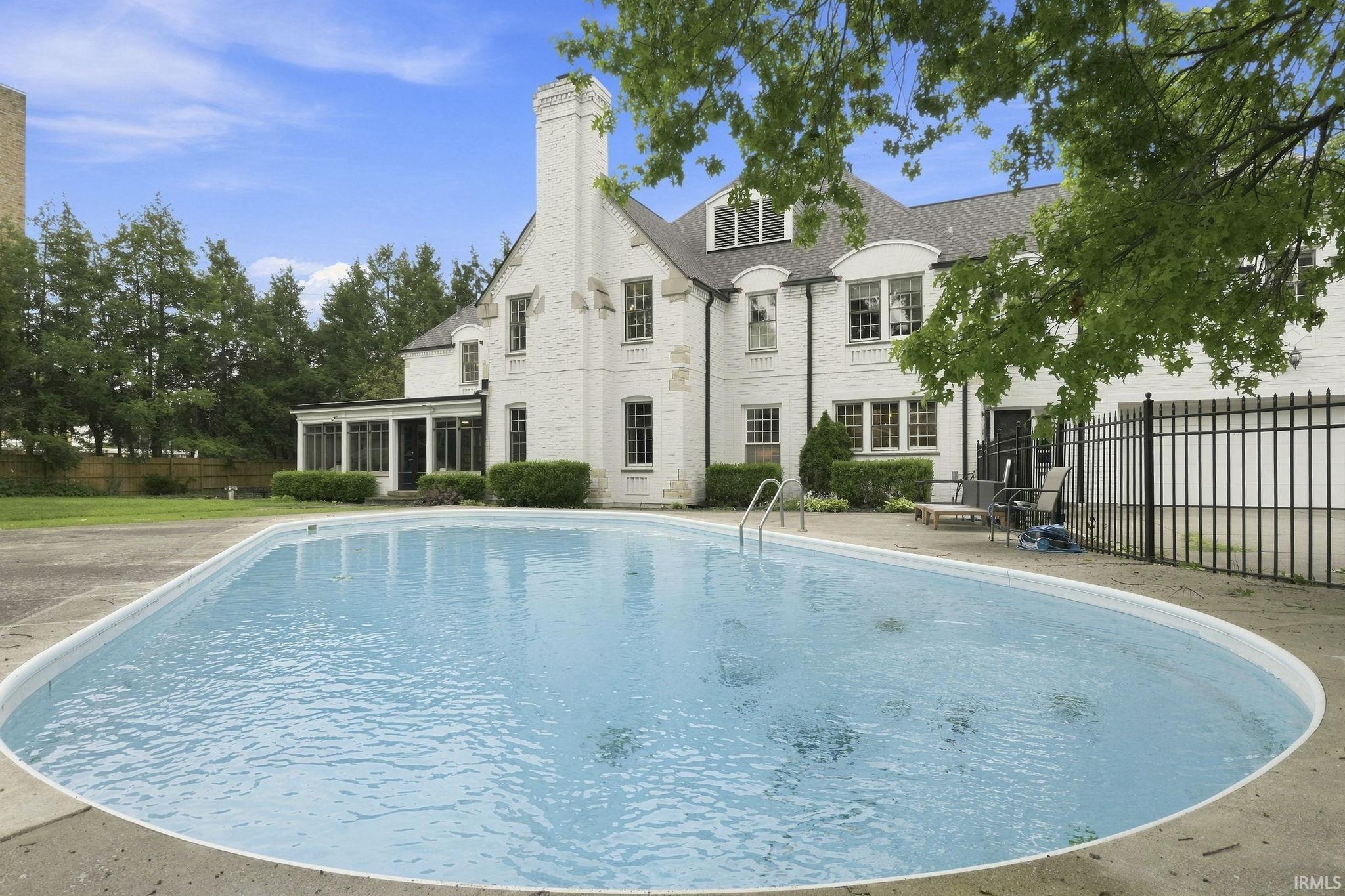 In-ground swimming pool with an irregular shape and concrete surround