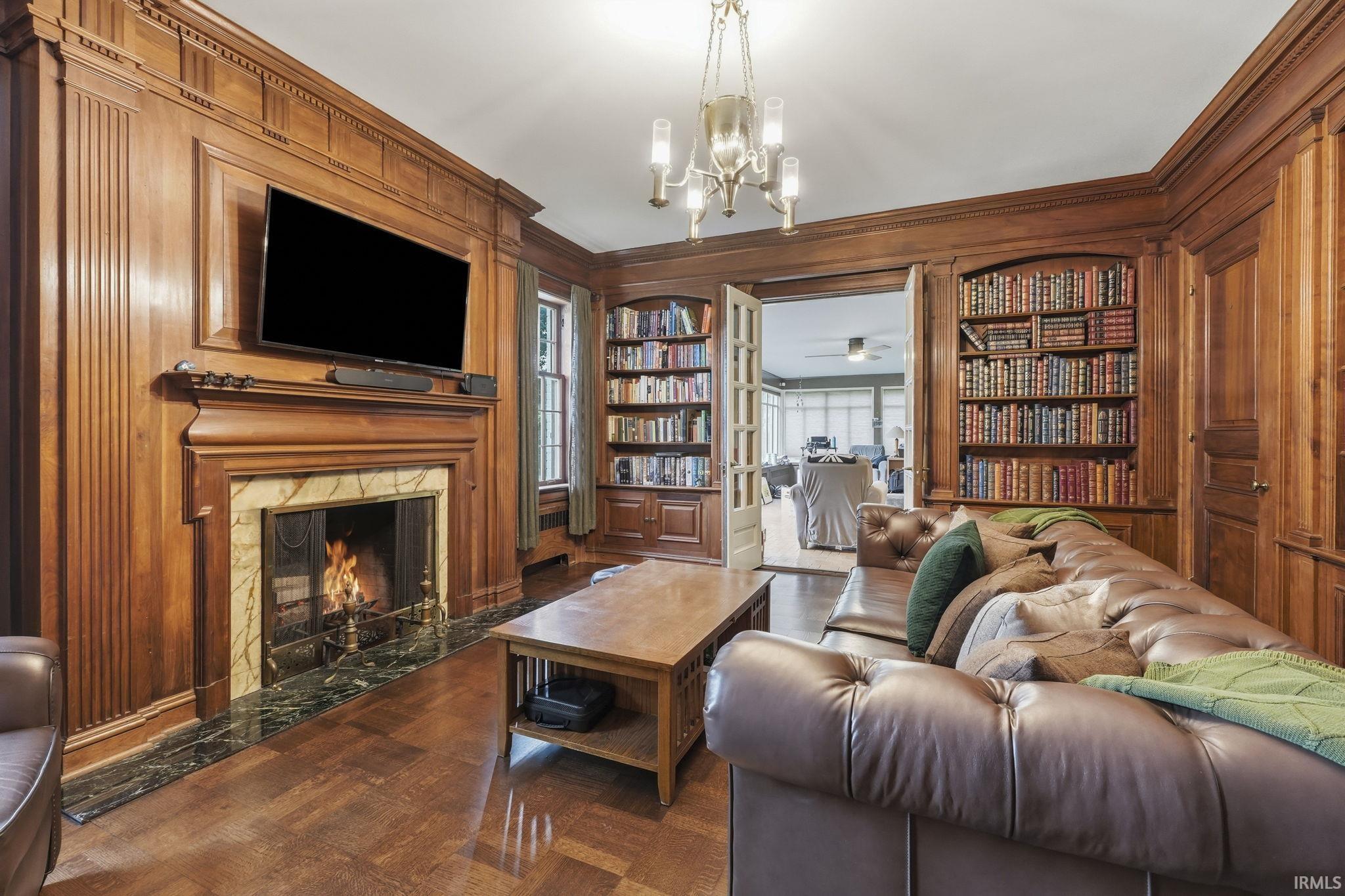 Wood-paneled walls featuring integrated shelving and a built-in fireplace with a stone surround
