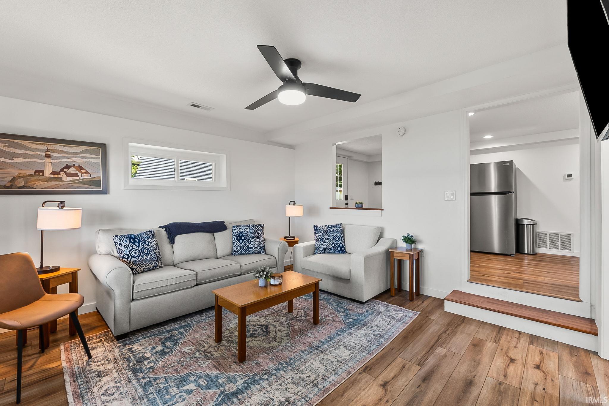 Recessed window, wood-finish flooring, ceiling fan, and stainless steel refrigerator
