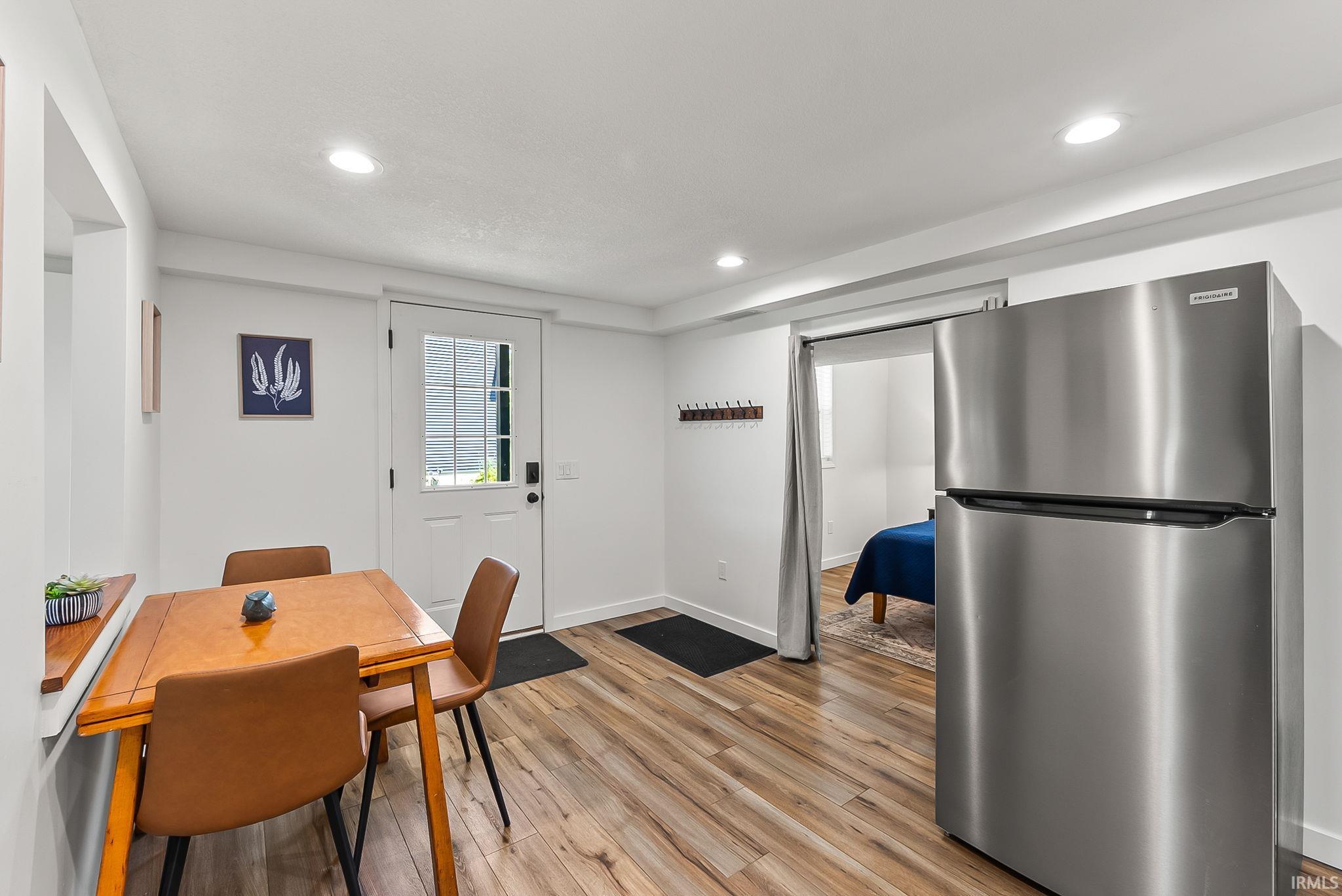 Wood-finish flooring, recessed lighting, and a stainless steel refrigerator