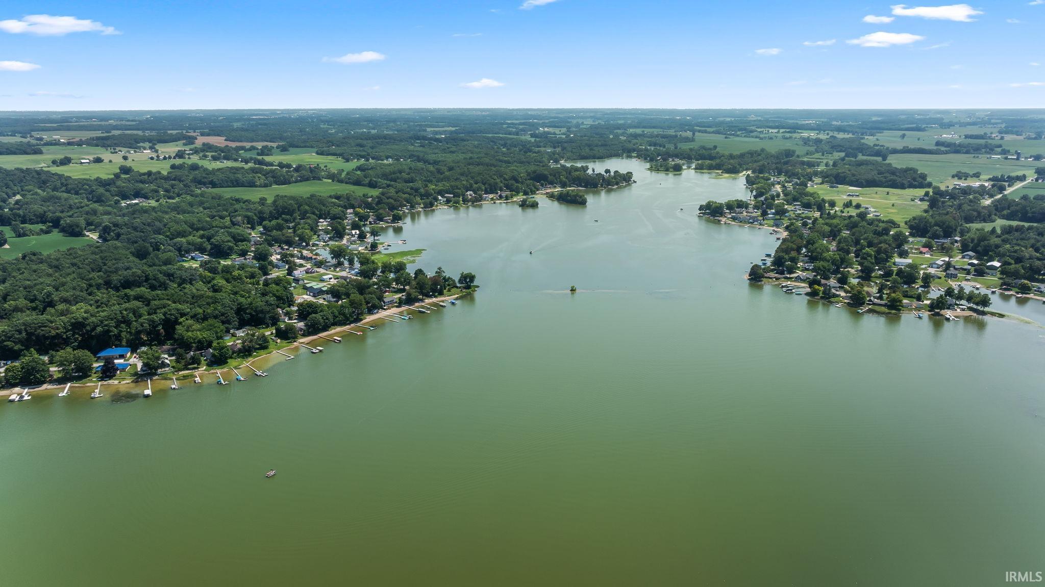 Expansive body of water surrounded by lush green foliage and numerous waterfront properties